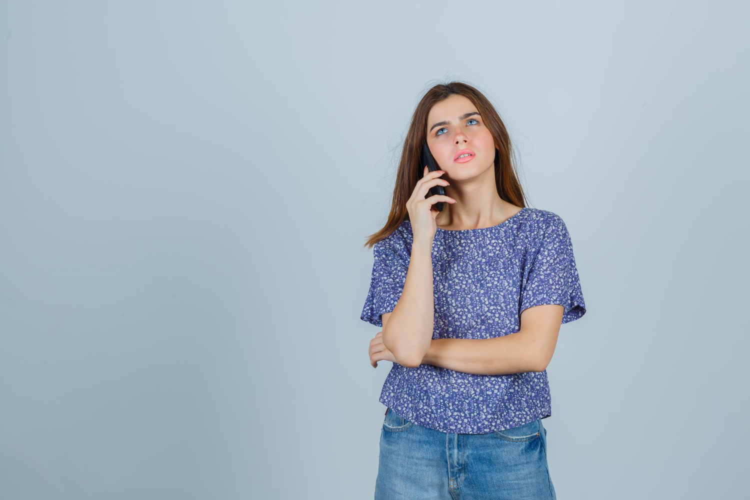 A concerned woman talking on the phone | Source: Freepik