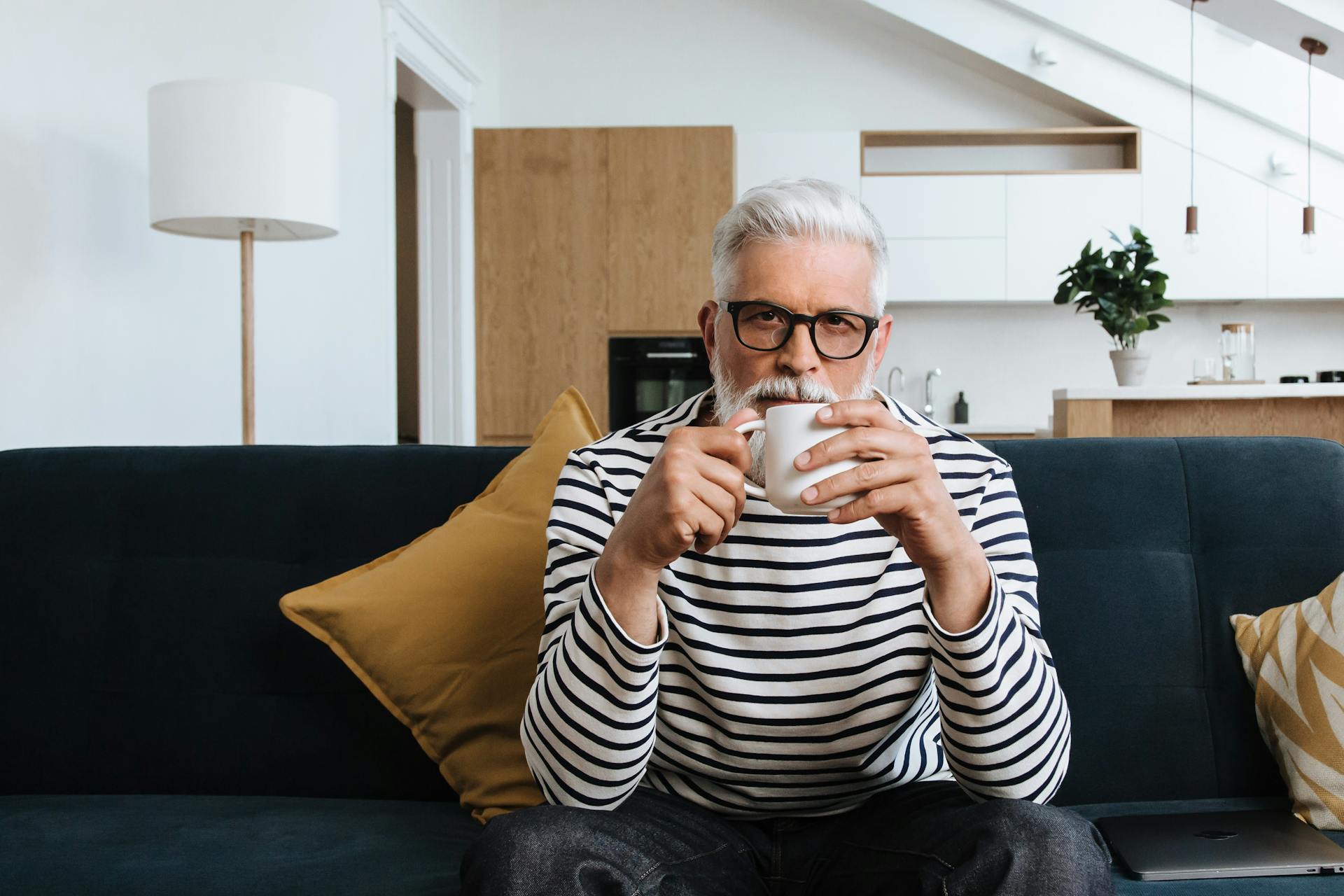 A senior man having tea while sitting on a sofa | Source: Pexels