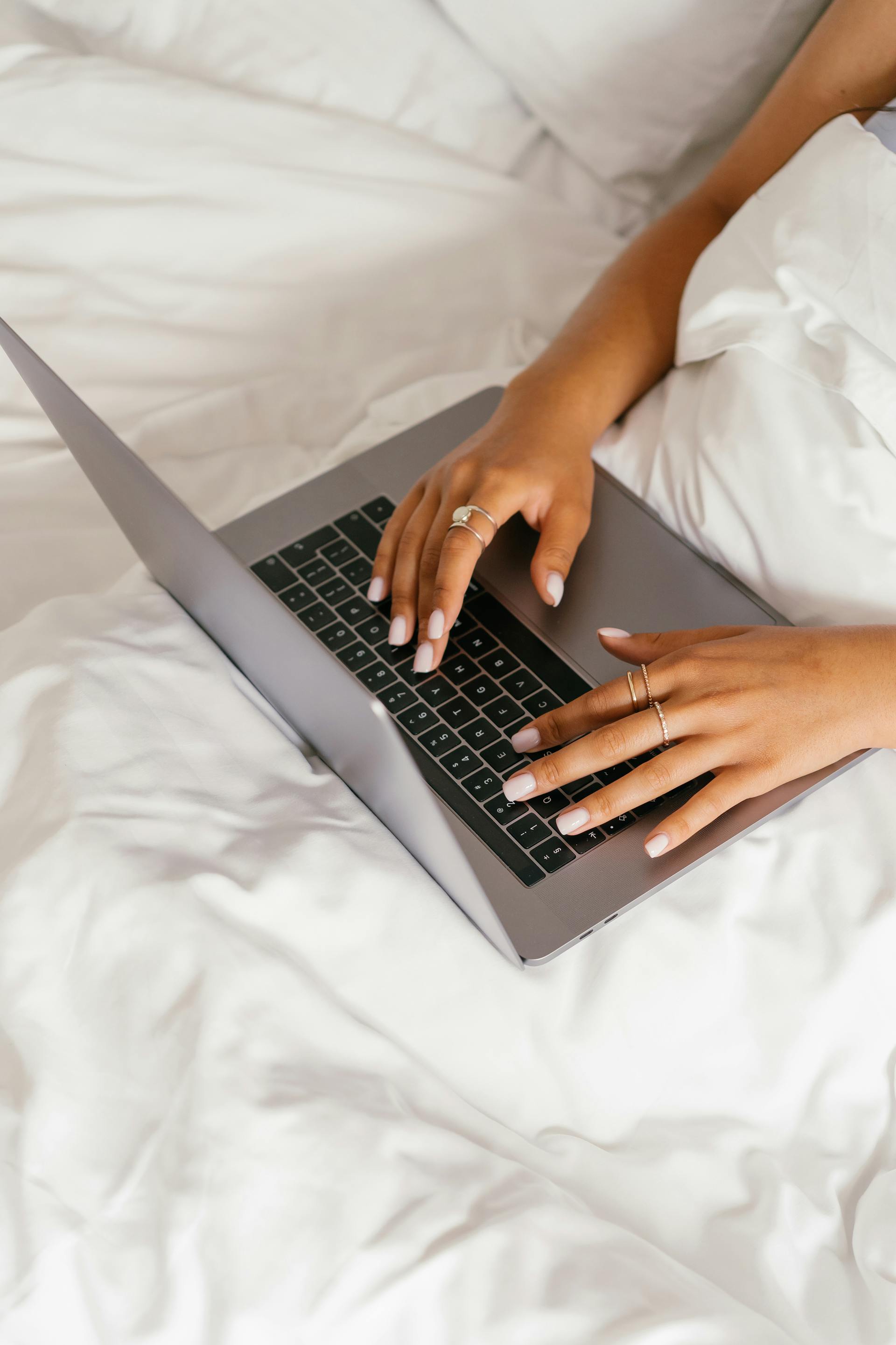 A woman using her laptop in bed | Source: Pexels