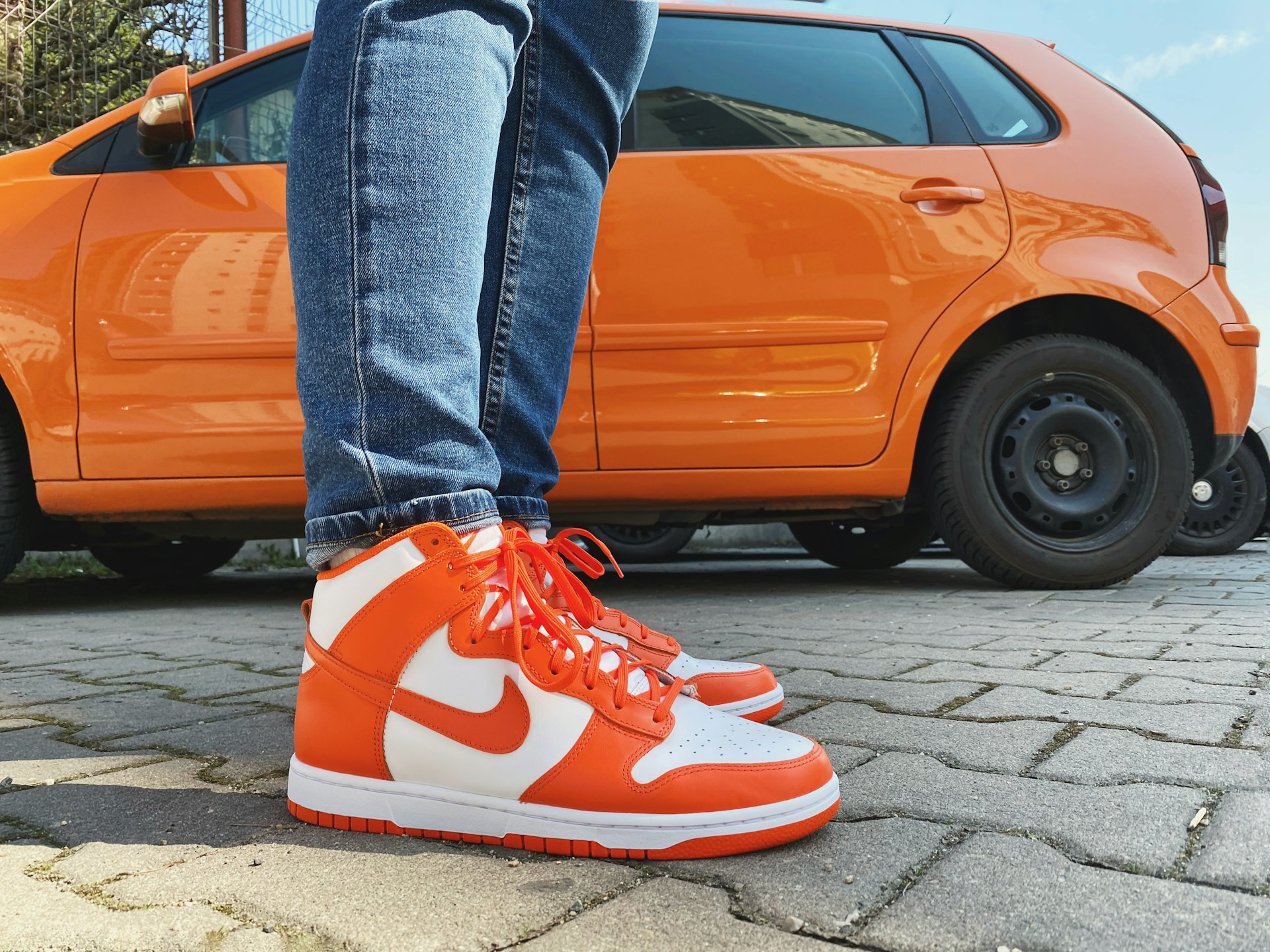 A man sporting branded shoes and standing beside a car | Source: Unsplash