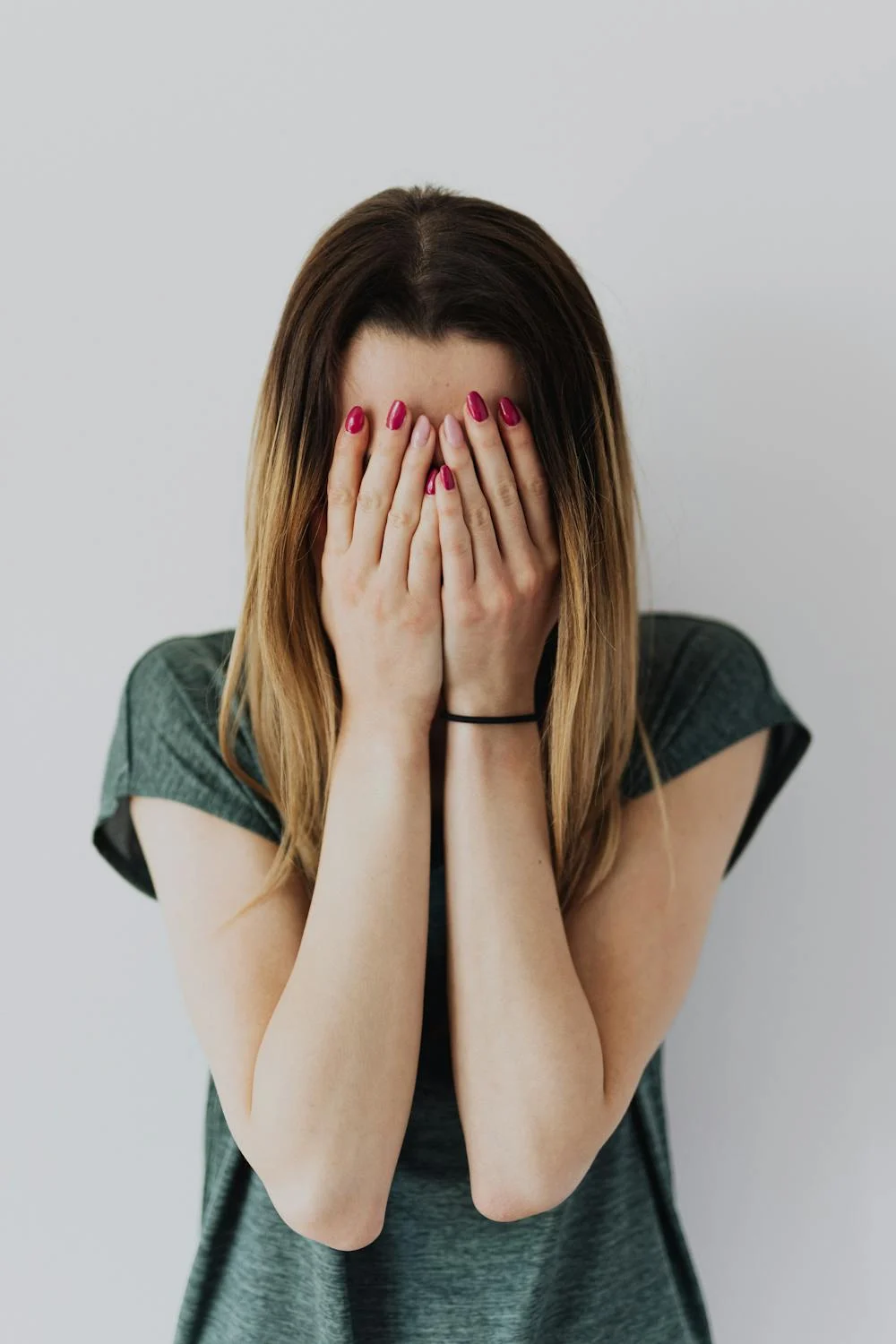 A woman covering her face with her hands | Source: Pexels