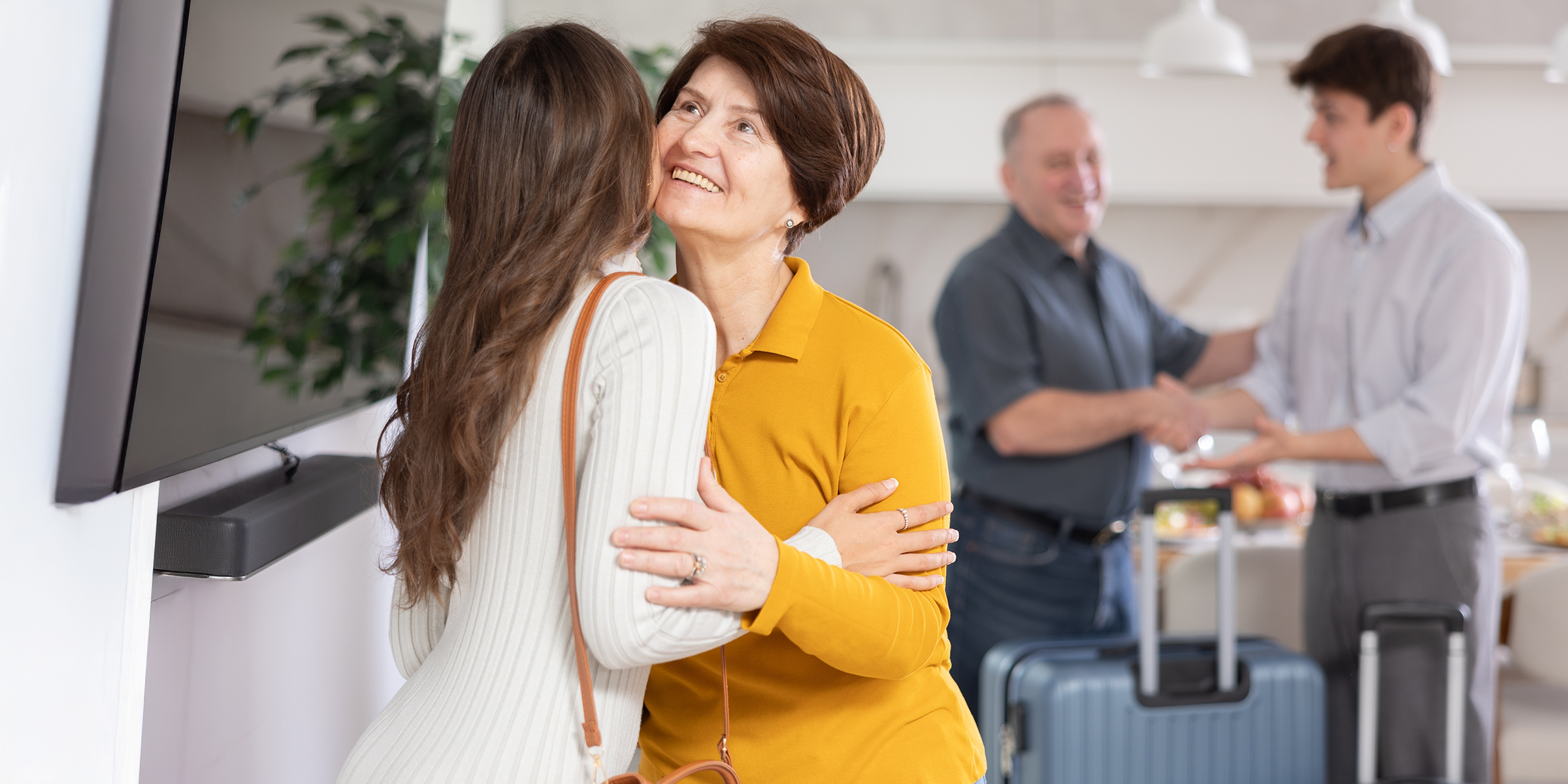 A young couple welcomes and older one | Source: Shutterstock