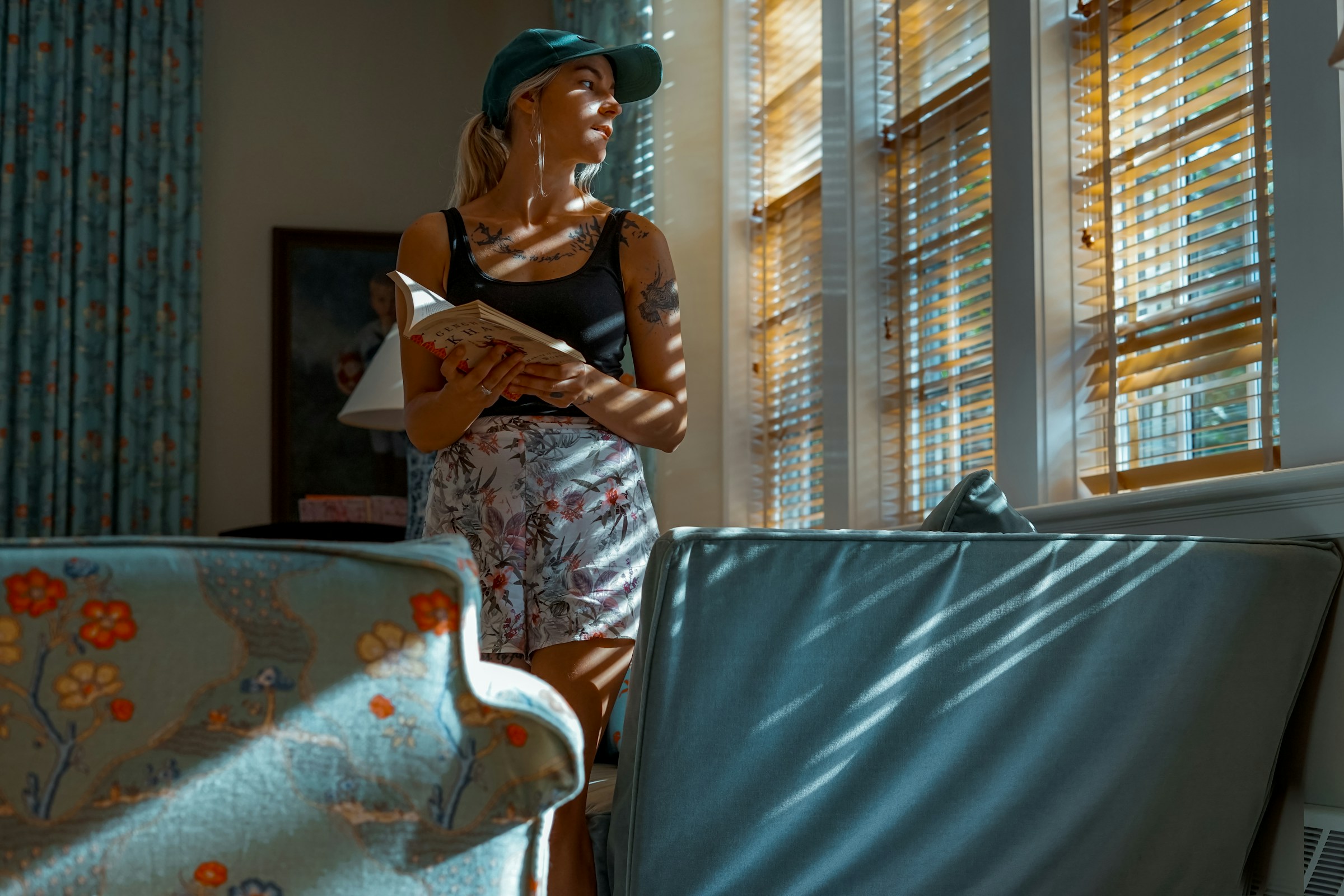 A woman looking out the window while holding a book | Source: Unsplash