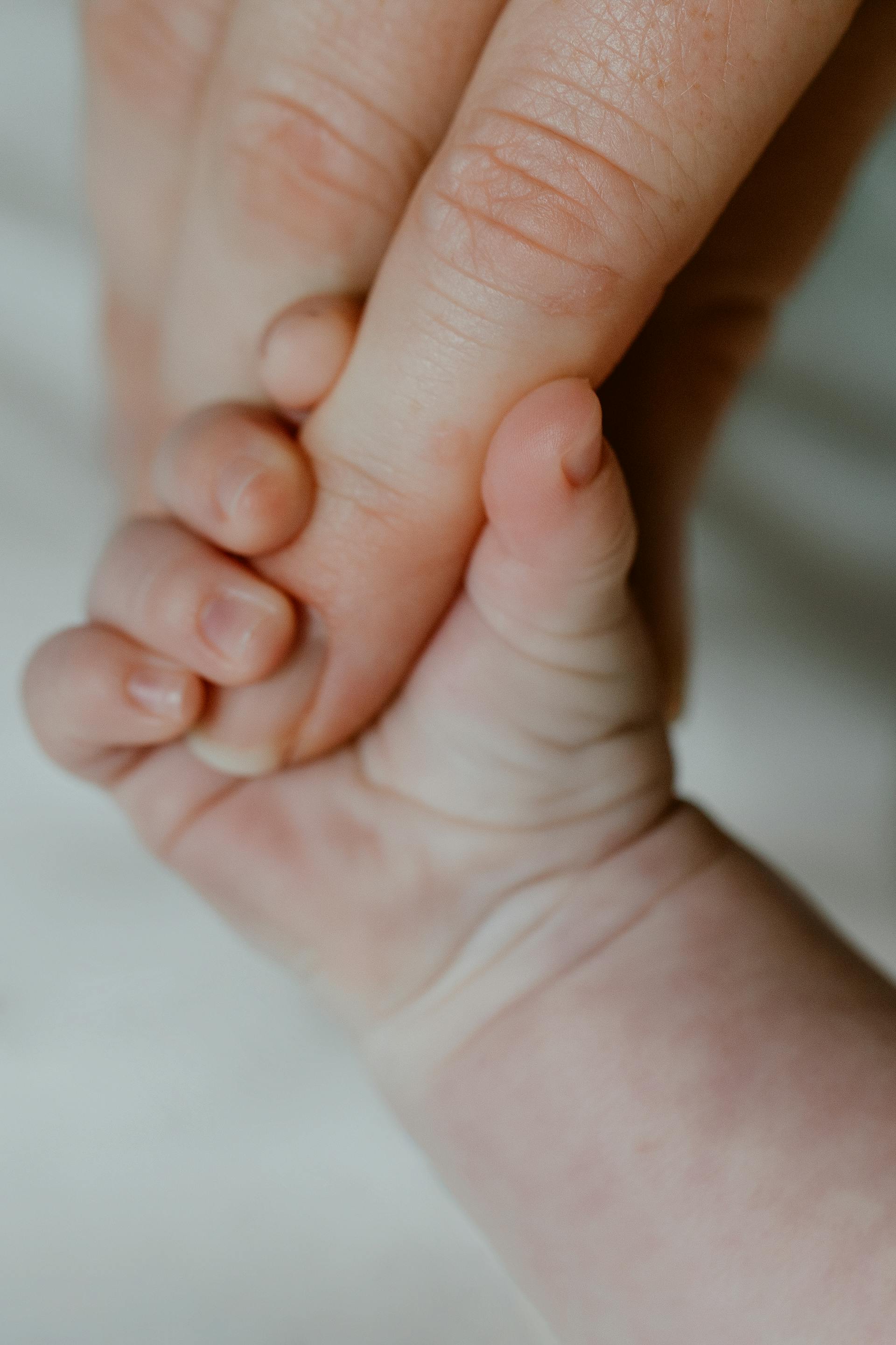 A baby holding his mother's finger | Source: Pexels