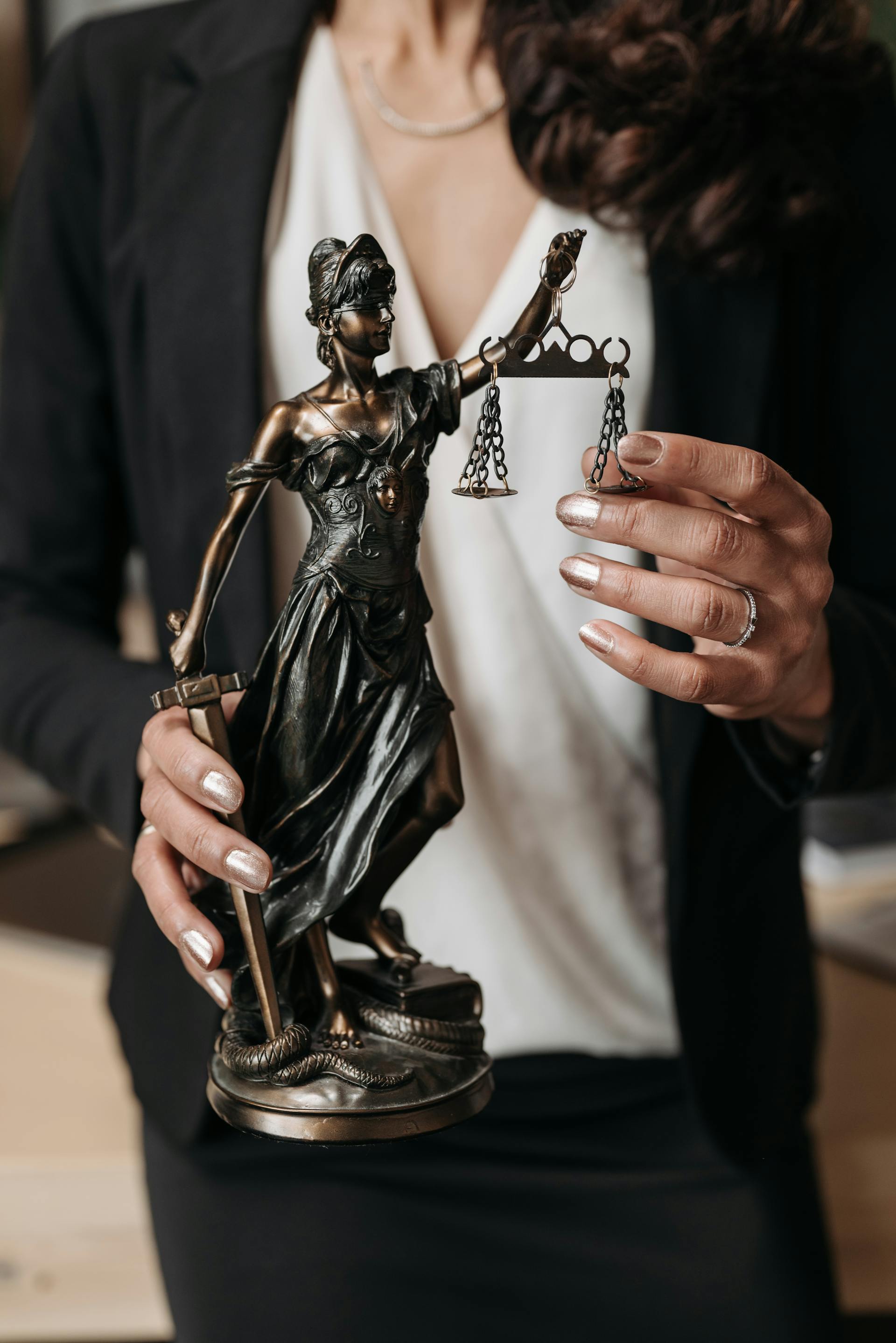 A close-up shot of a woman holding a statuette of Lady Justice | Source: Pexels