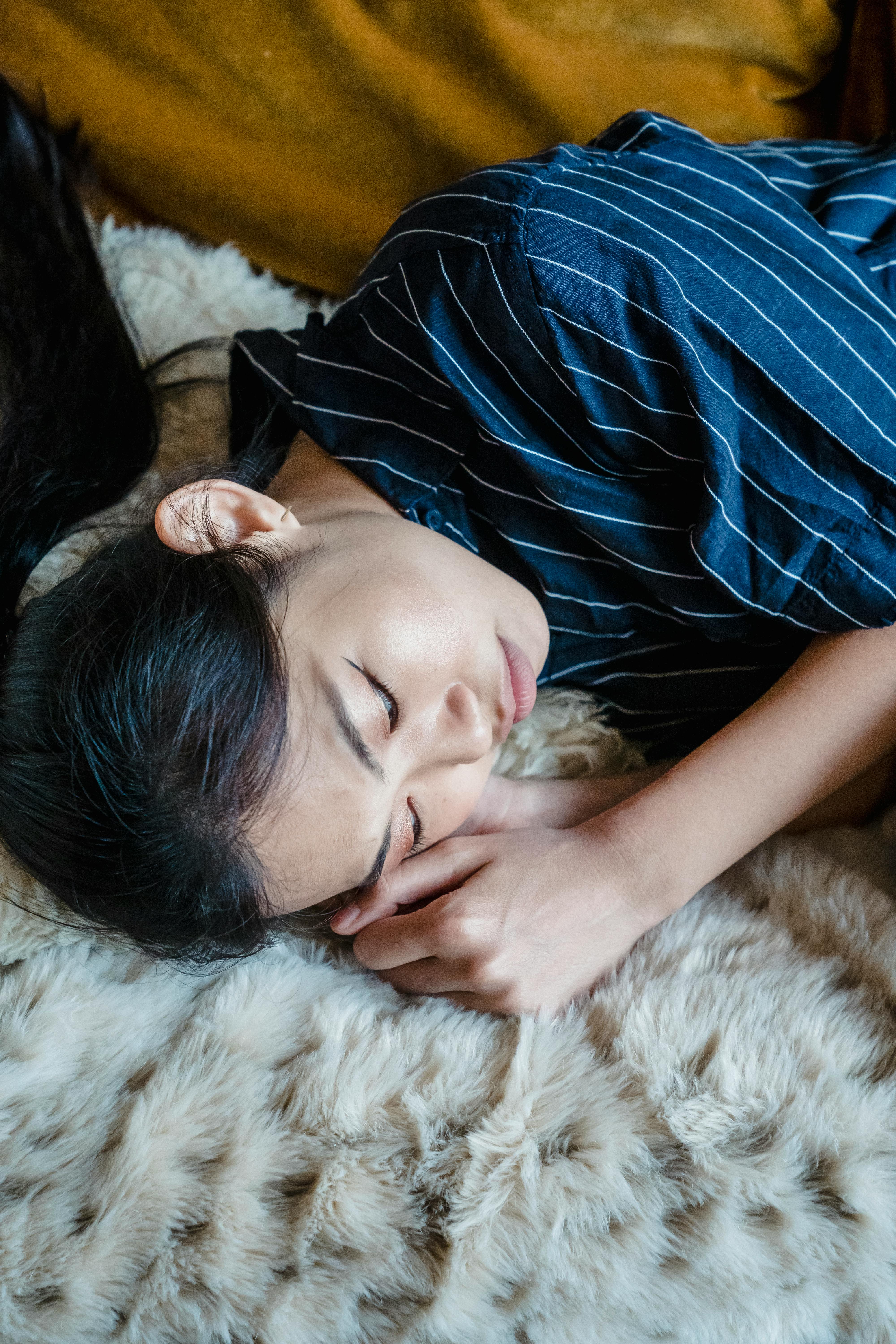 A sad woman lying on a bed | Source: Pexels