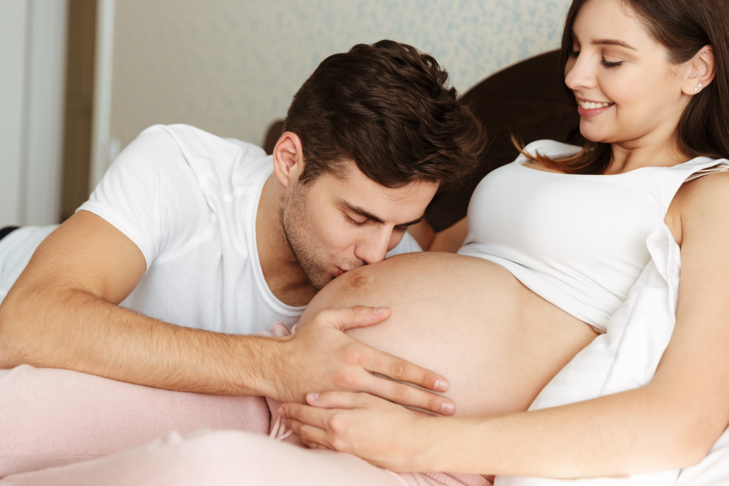 A man kissing his pregnant partner's baby bump | Source: Freepik