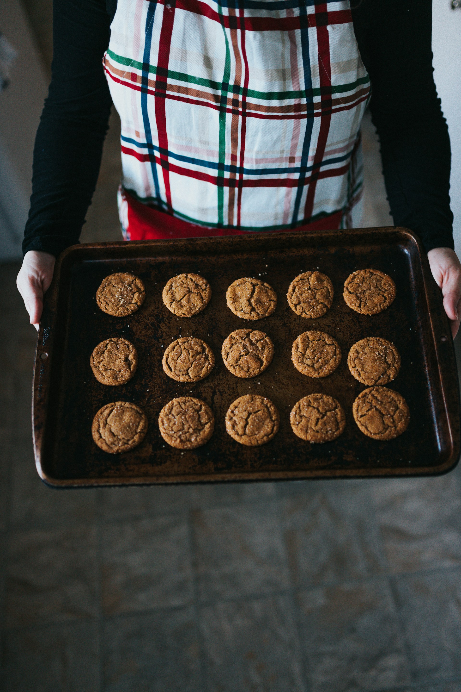 A woman holding a baking tray with cookies | Source: Unsplash
