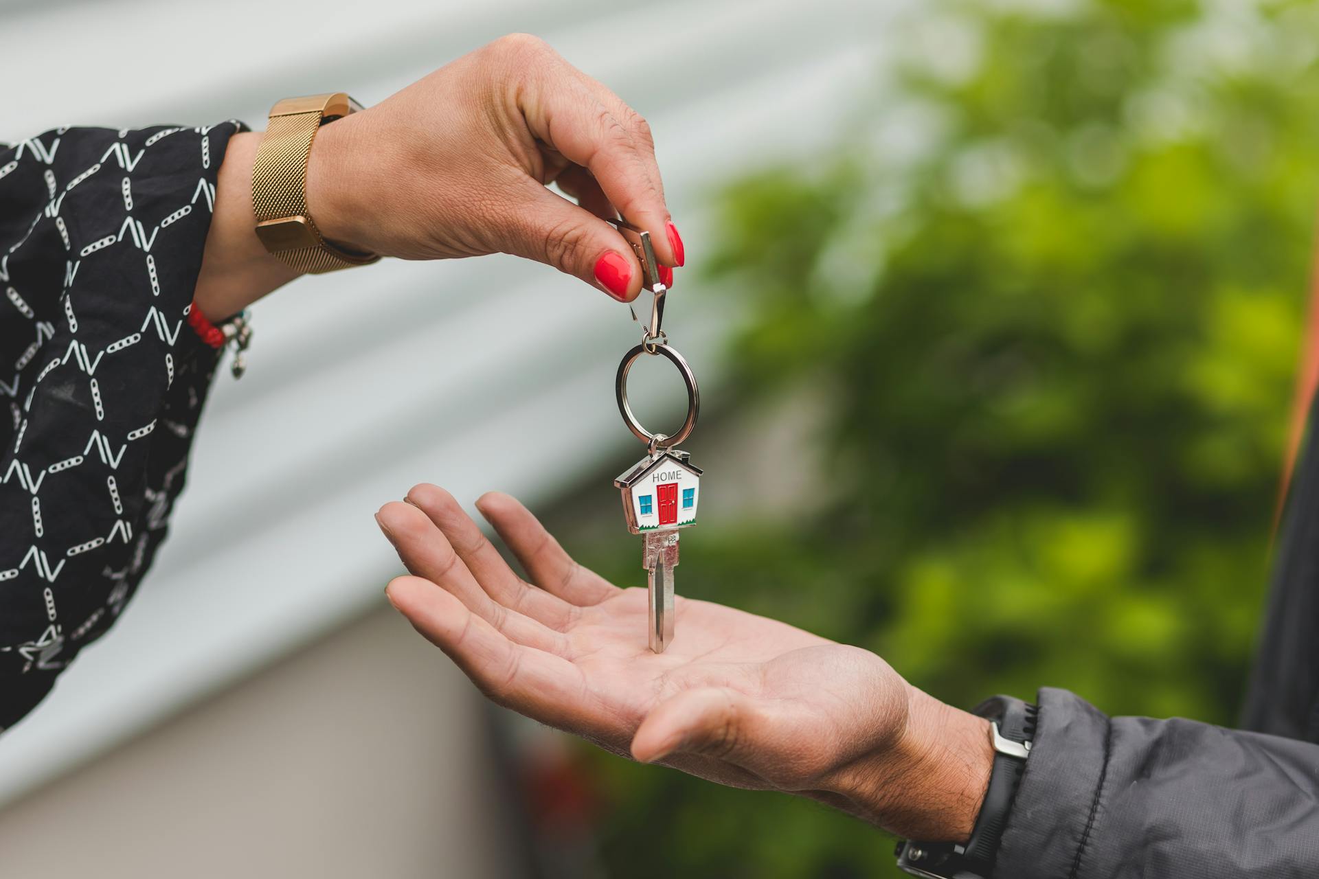 A person handing keys to another person | Source: Pexels