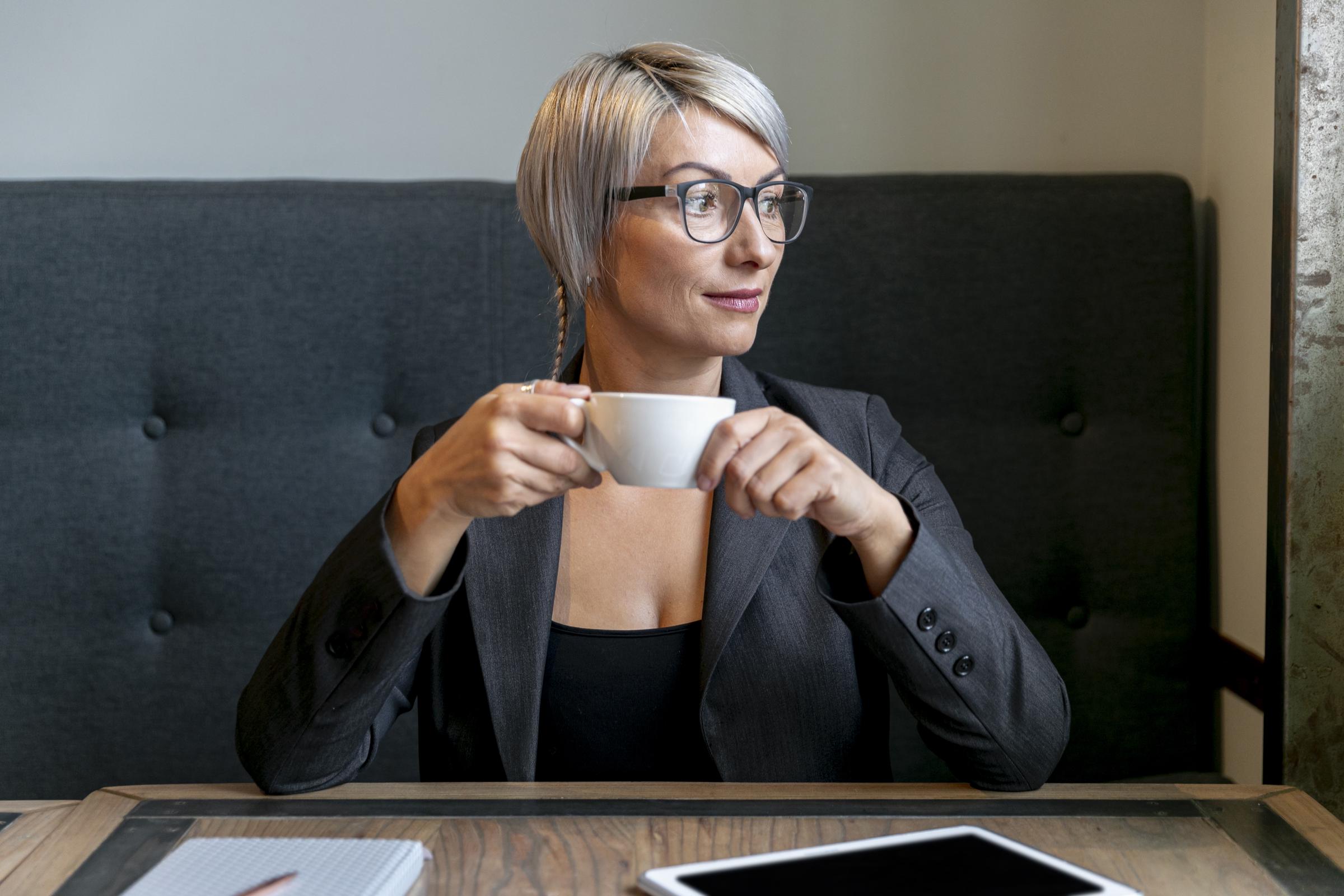 A cheerful woman holding a cup of coffee | Source: Freepik