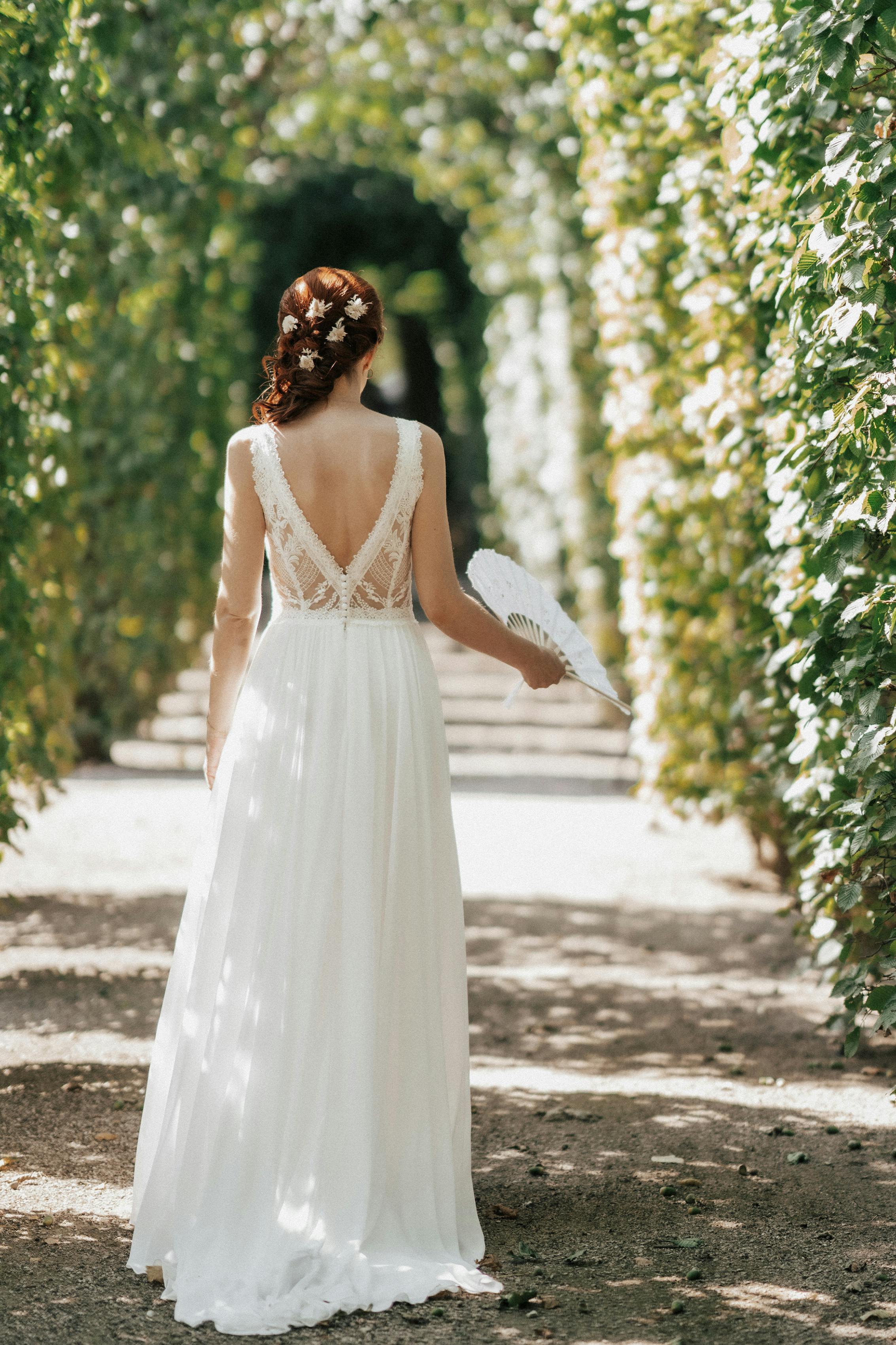 Bride in an elegant lace dress in garden archway | Source: Pexels