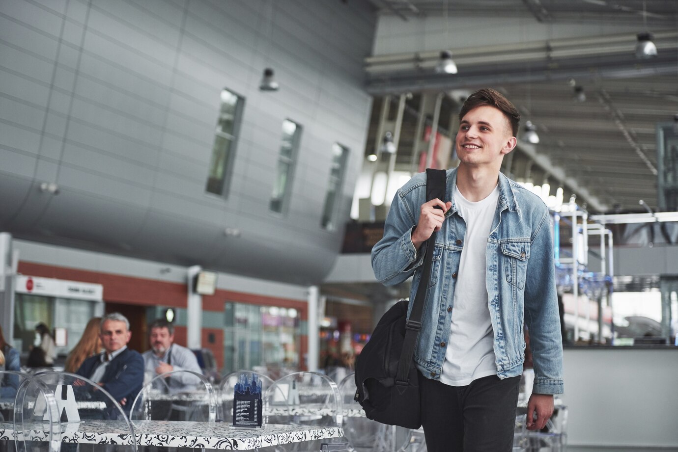 A smiling man walking in an airport | Source: Freepik