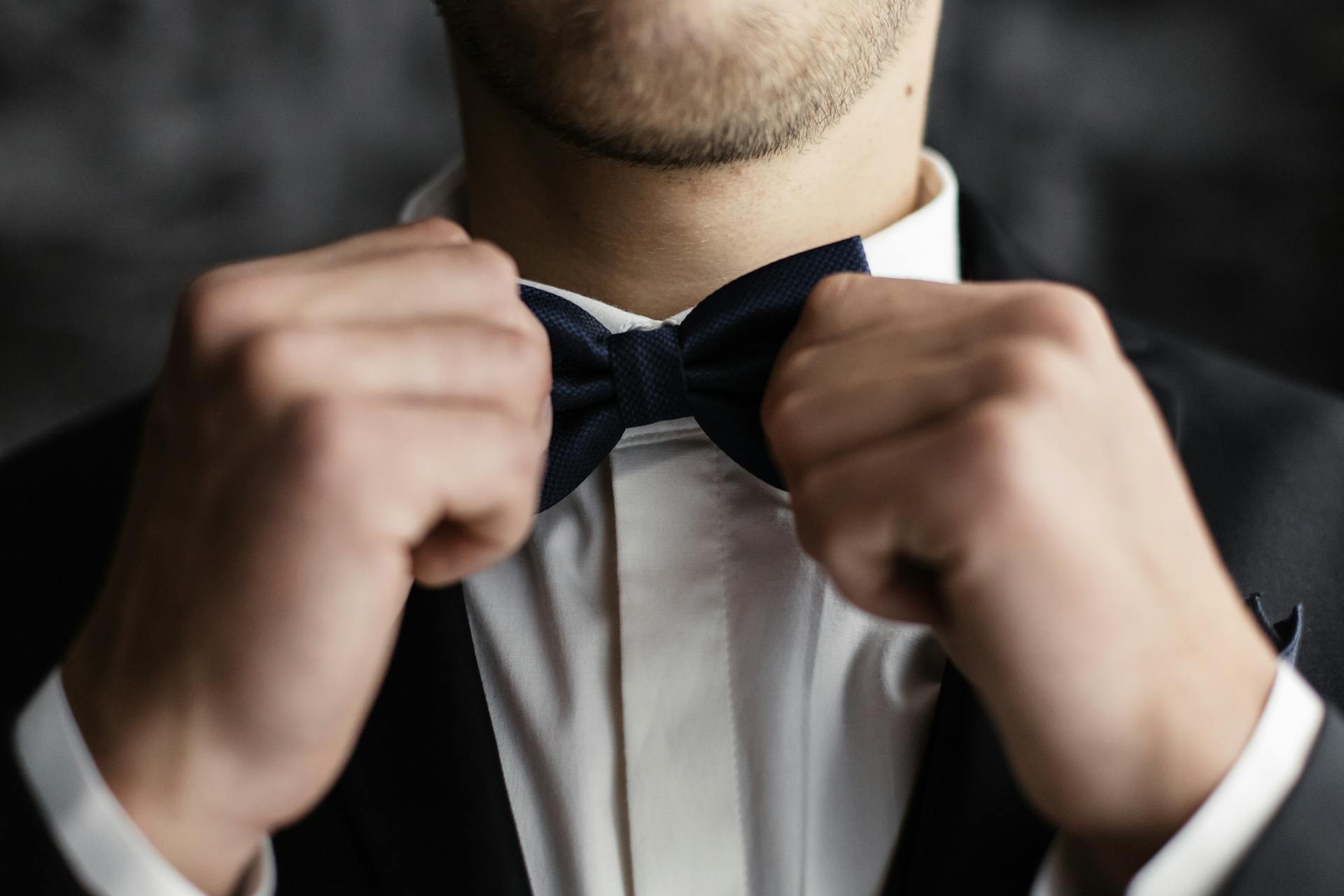 A groom adjusting his bow tie | Source: Pexels