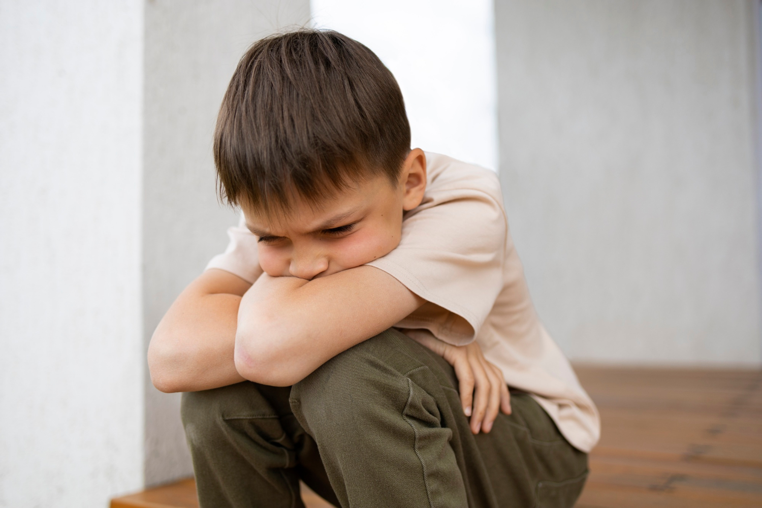 A sad little boy sitting alone | Source: Freepik