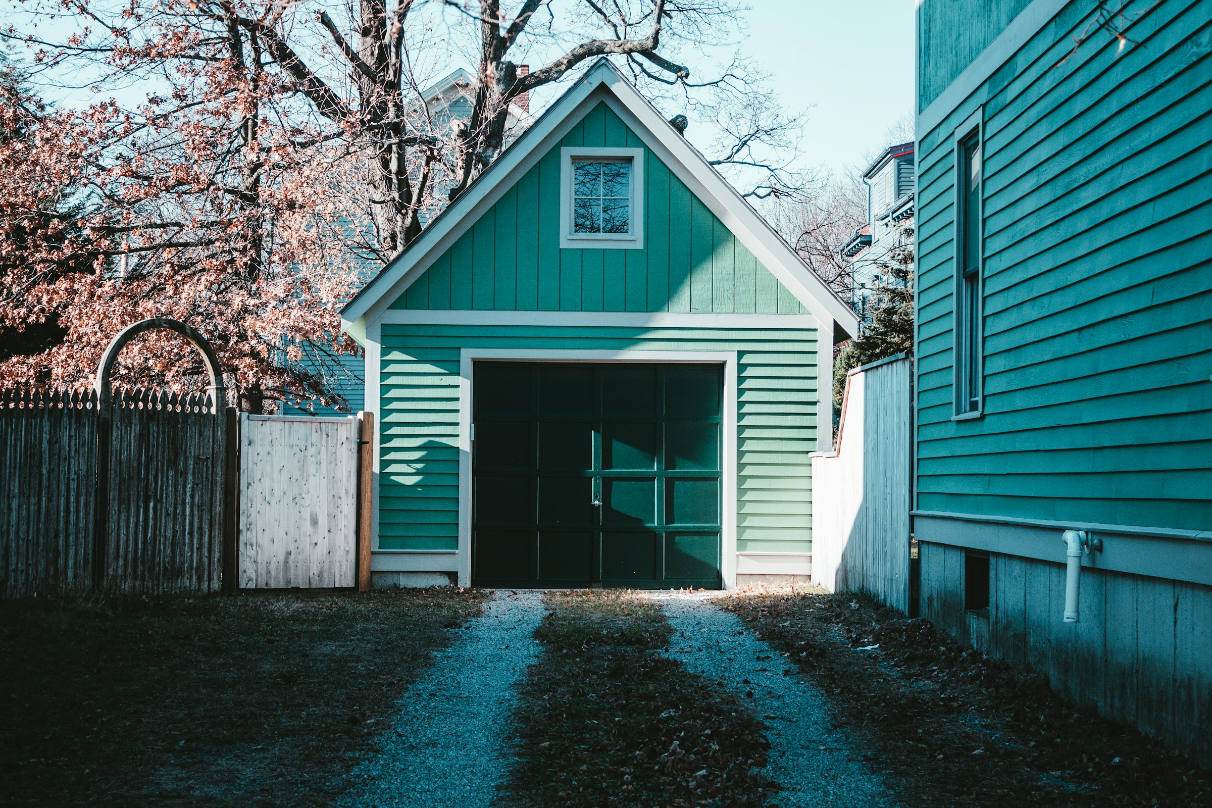 A teal-colored house and garage in a backyard | Source: Unsplash