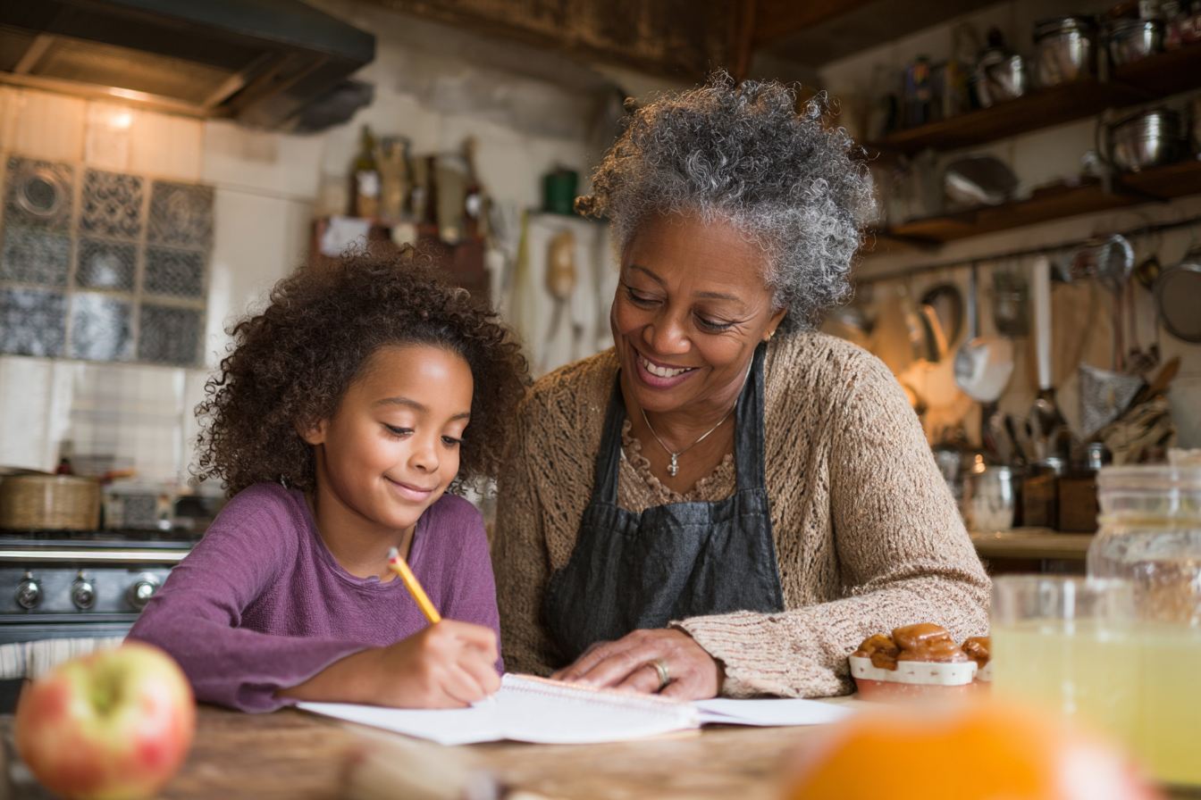 A woman helping her granddaughter with homework | Source: Midjourney
