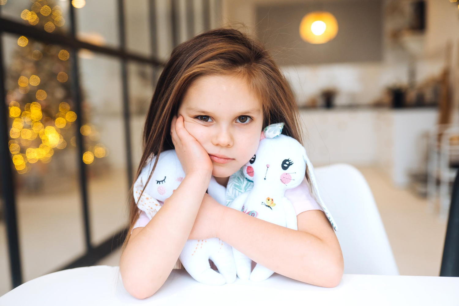 A sad little girl holding her stuffed toys and sitting in her room | Source: Freepik