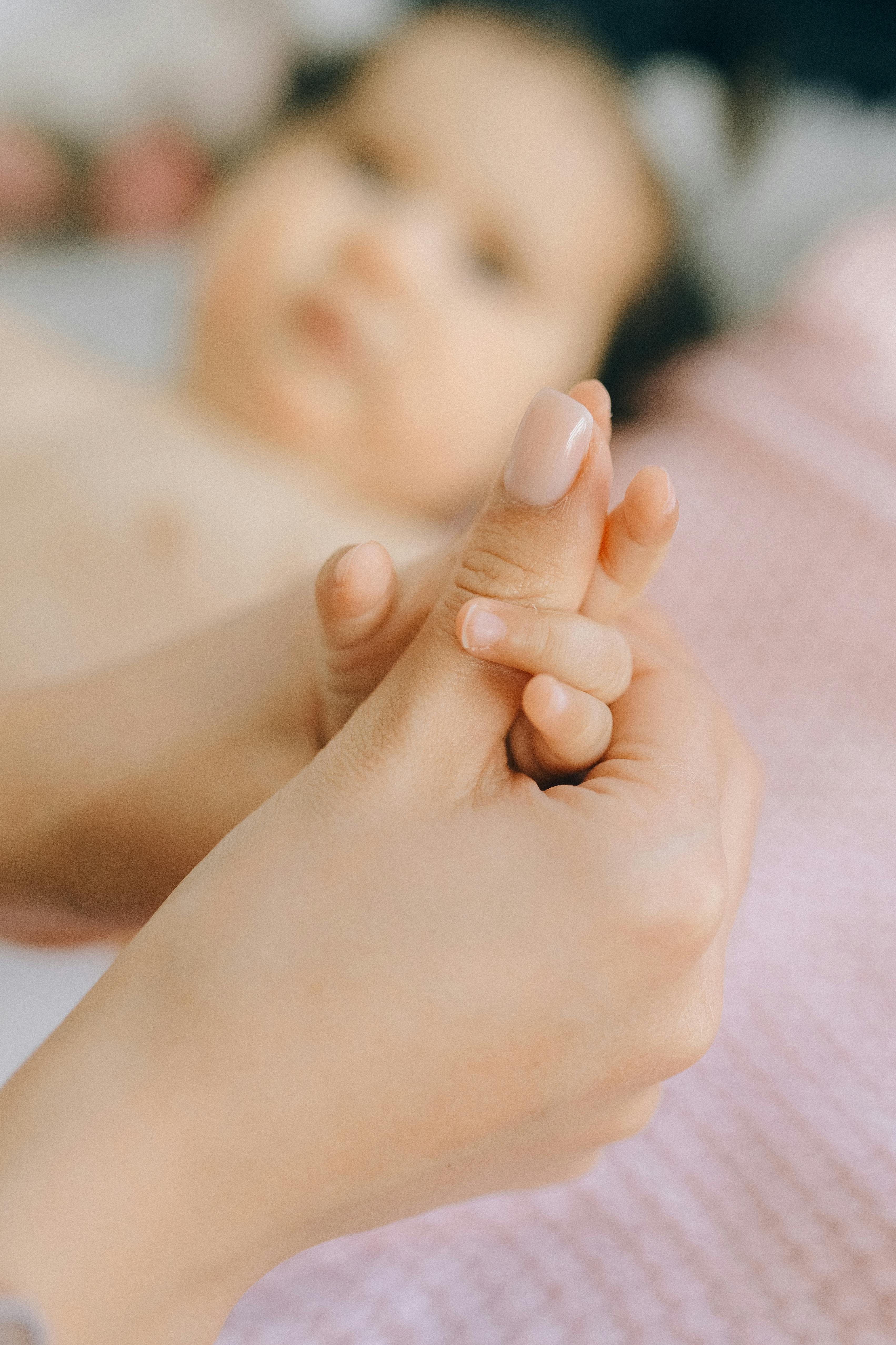 A newborn baby holding its mother's hand | Source: Pexels