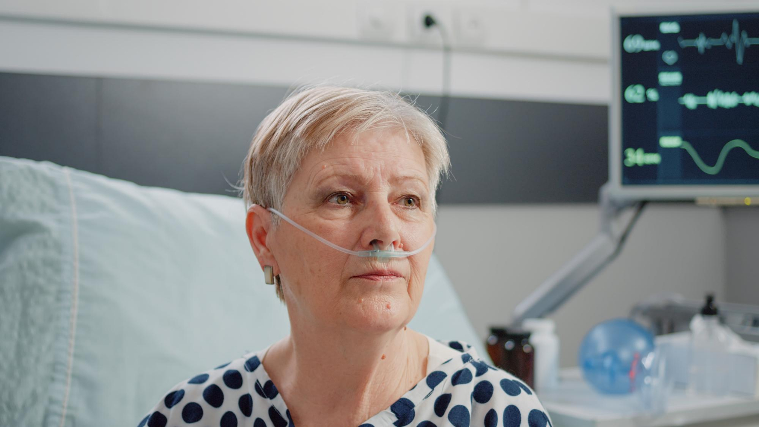 An aged woman sitting in a hospital ward and staring | Source: Freepik