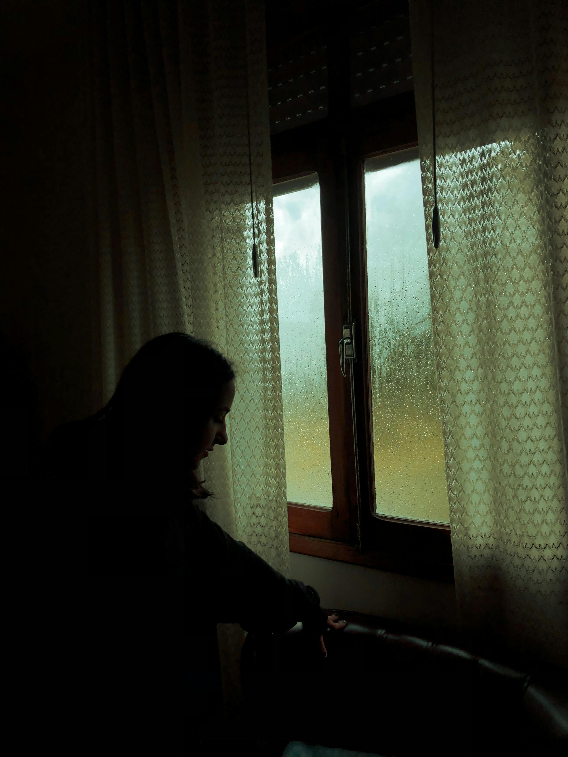 A woman standing near a window | Source: Pexels