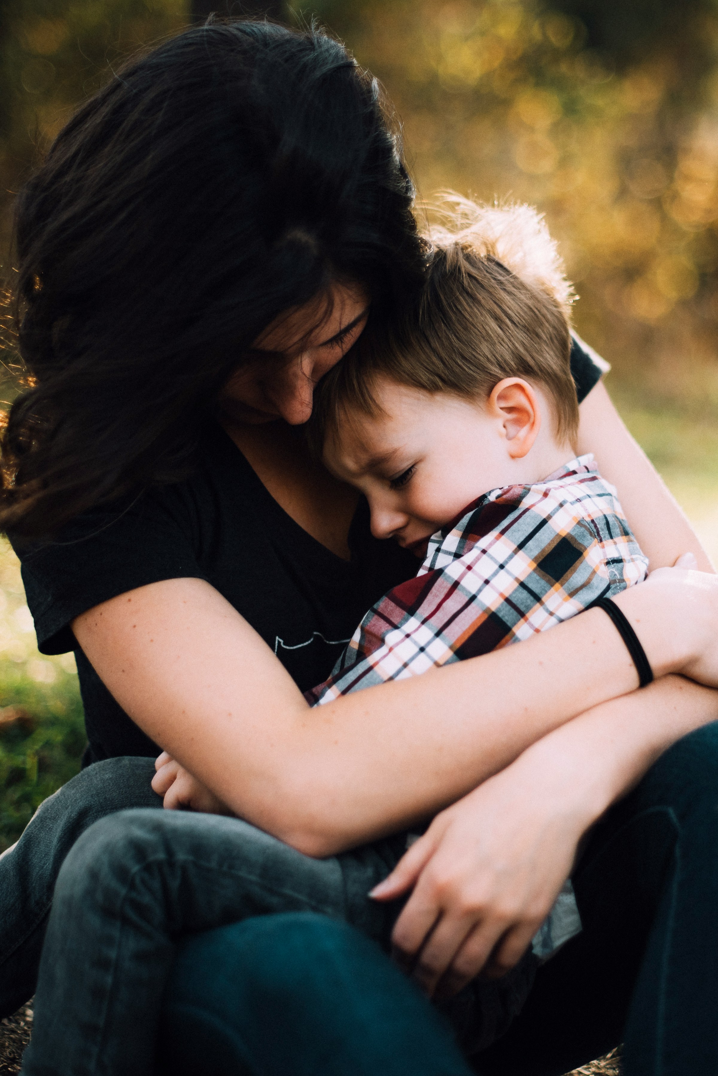 A woman embracing a heartbroken little boy | Source: Unsplash