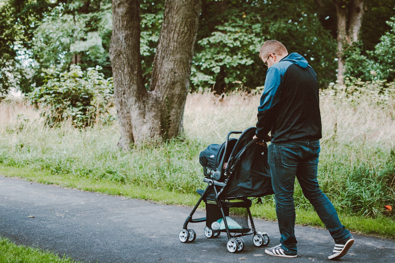 A man pushing a baby stroller | Source: Pexels