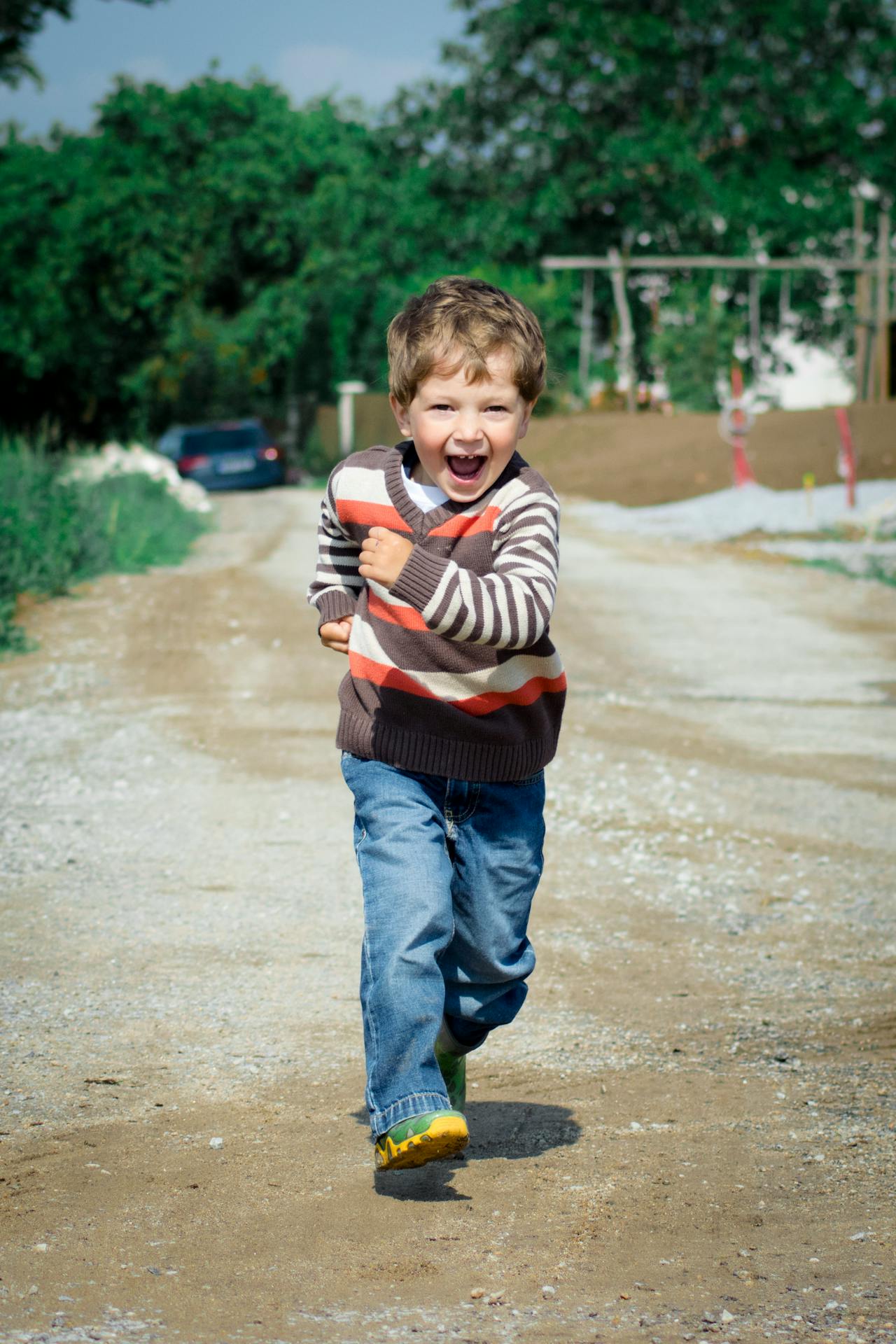 Um menino feliz caminhando na estrada | Fonte: Pexels