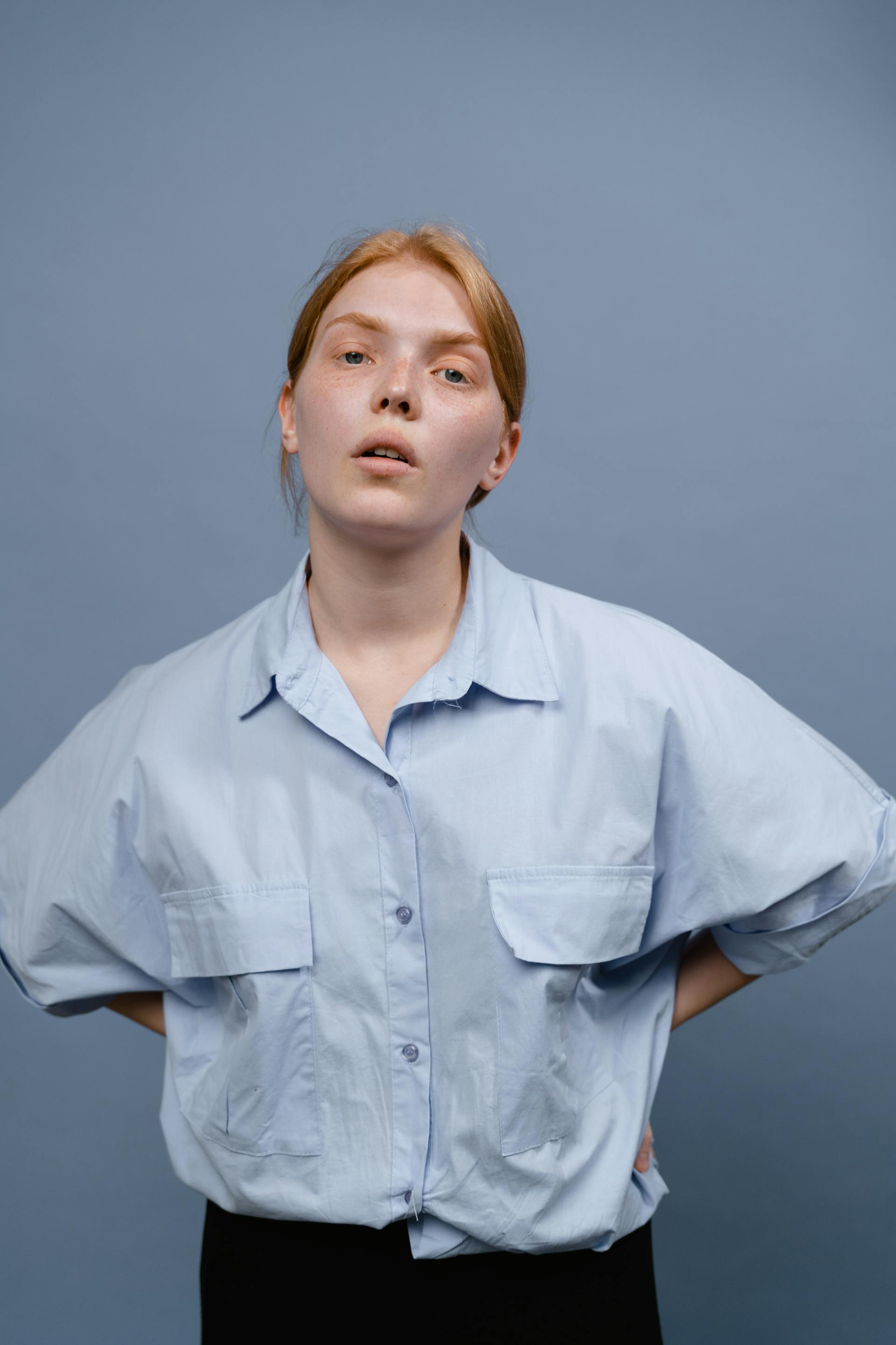 A woman with her hands on her hips and a tired expression | Source: Pexels
