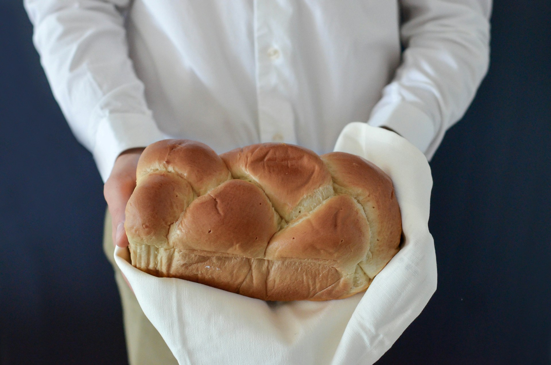 Close-up shot of a woman holding freshly baked bread | Source: Unsplash