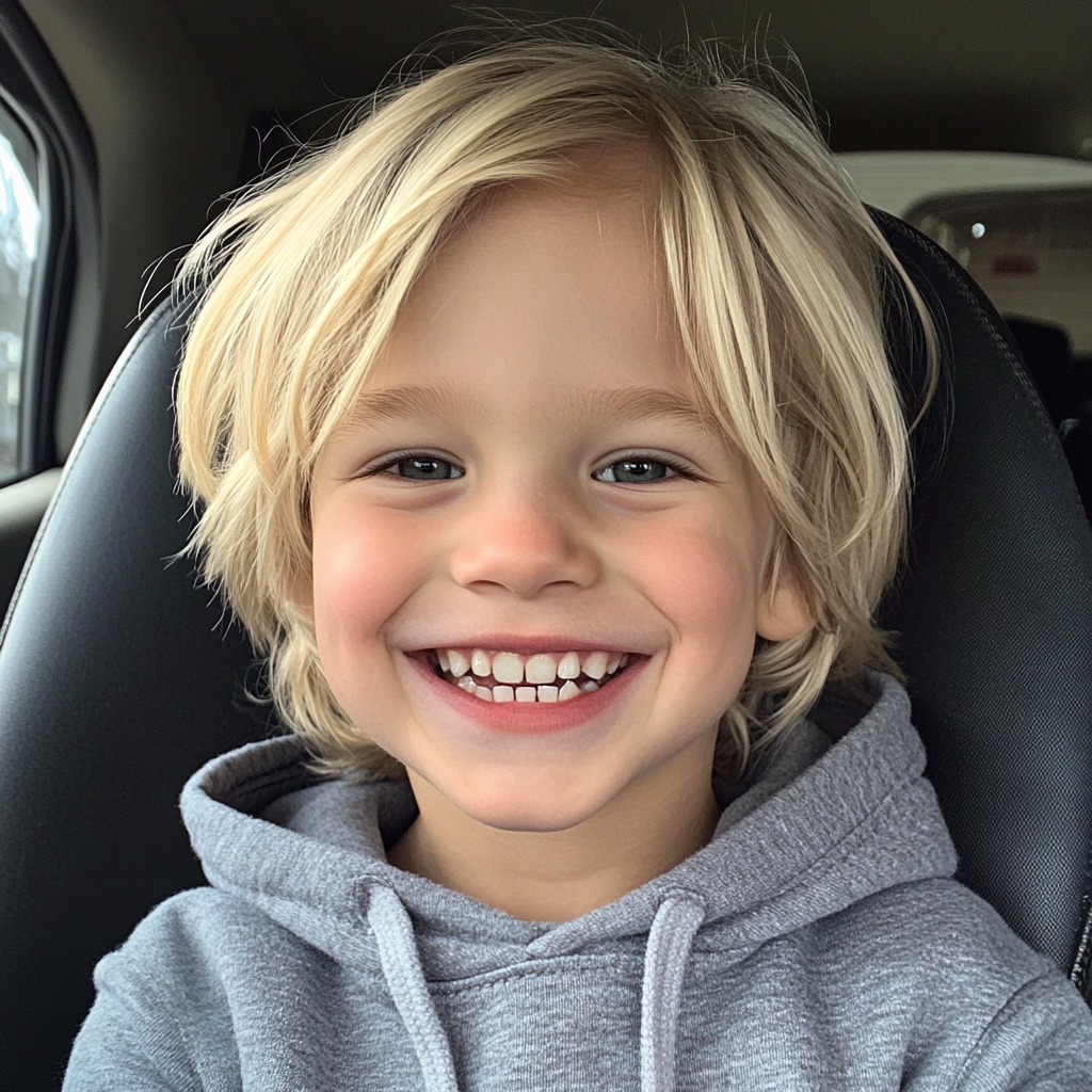 A smiling little boy sitting in a car | Source: Midjourney