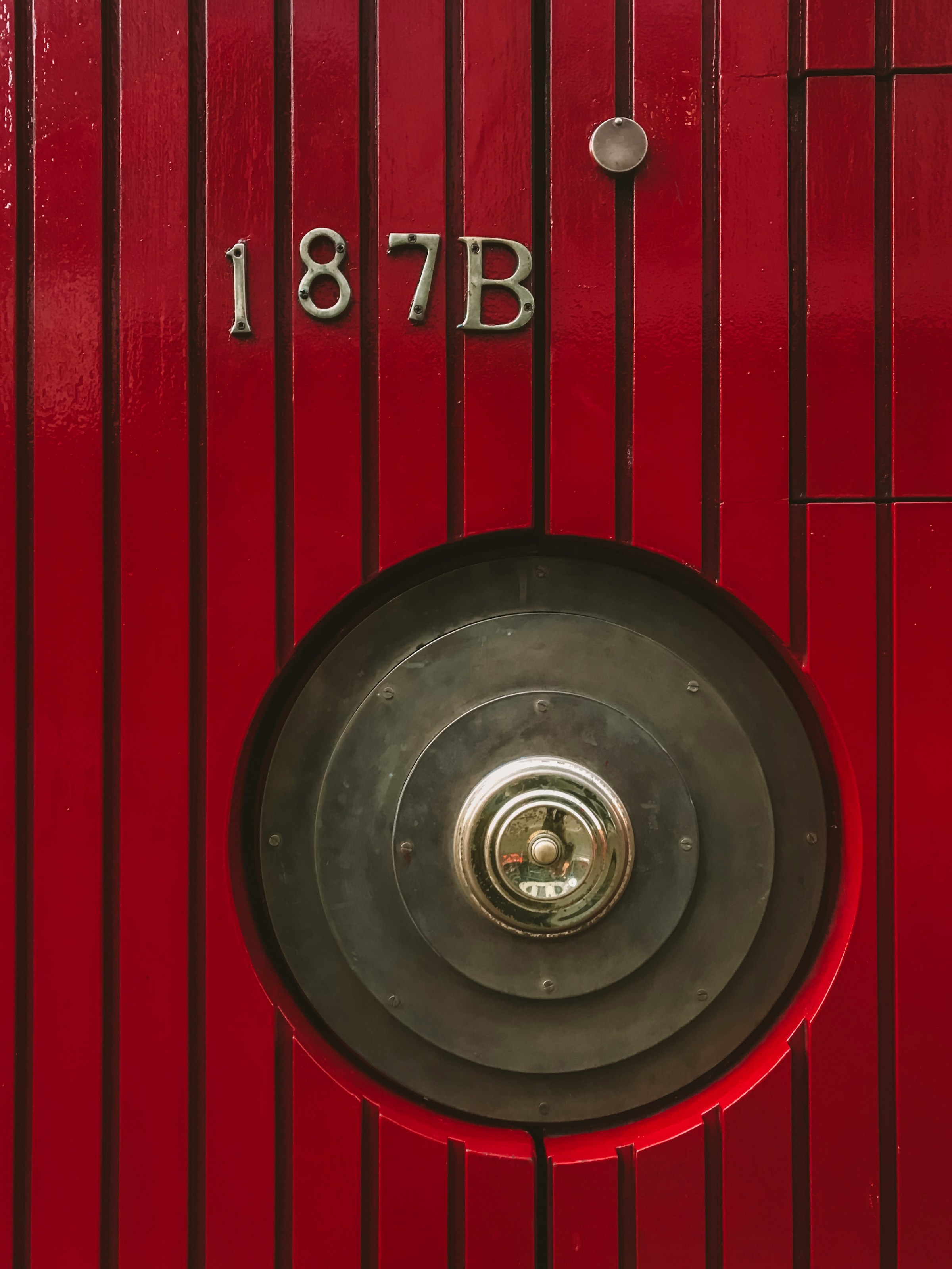 Uma porta vermelha com maçaneta de metal | Fonte: Unsplash