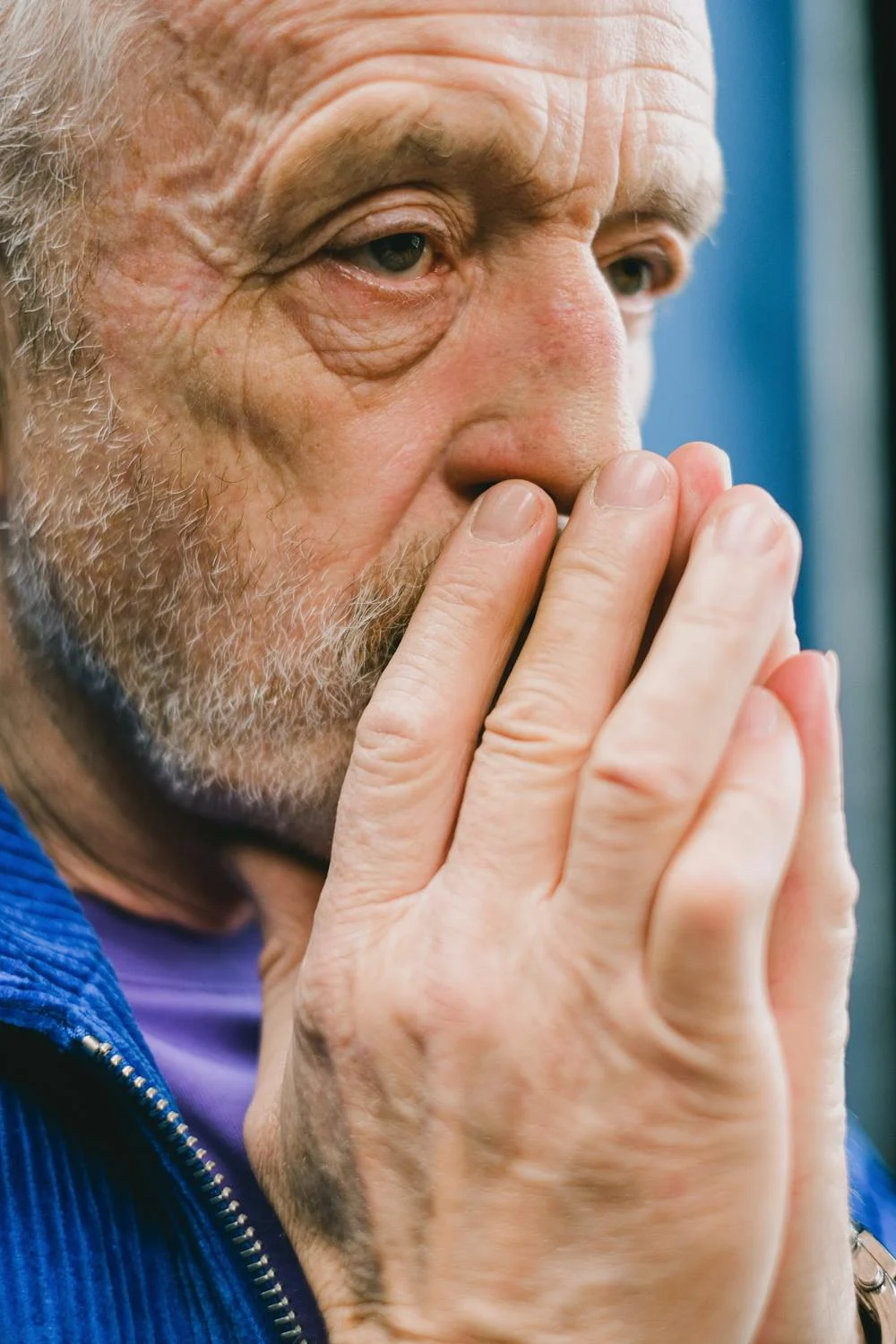 A serious man covering his mouth ⏐ Source: Pexels