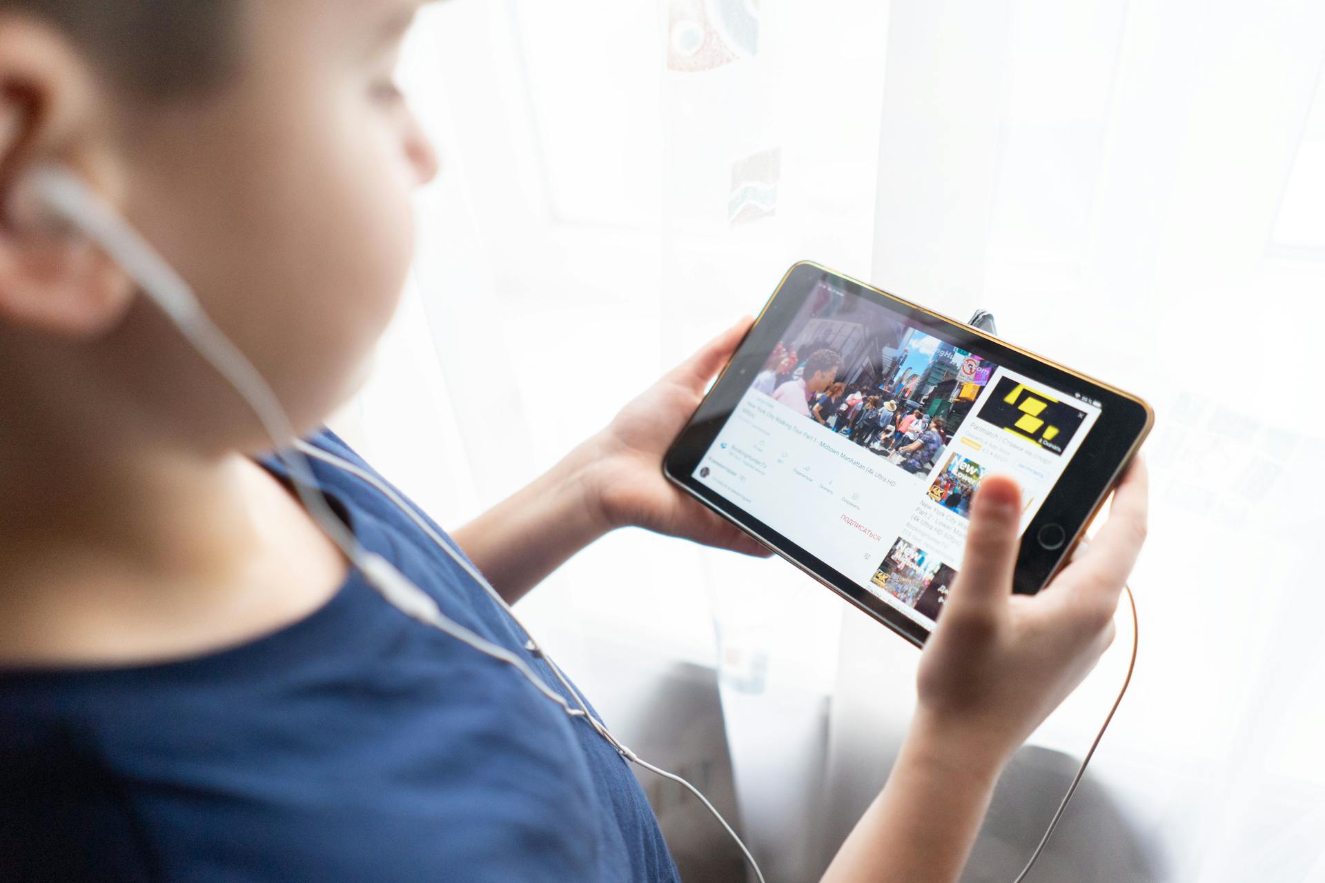 A boy holding a tablet | Source: Pexels