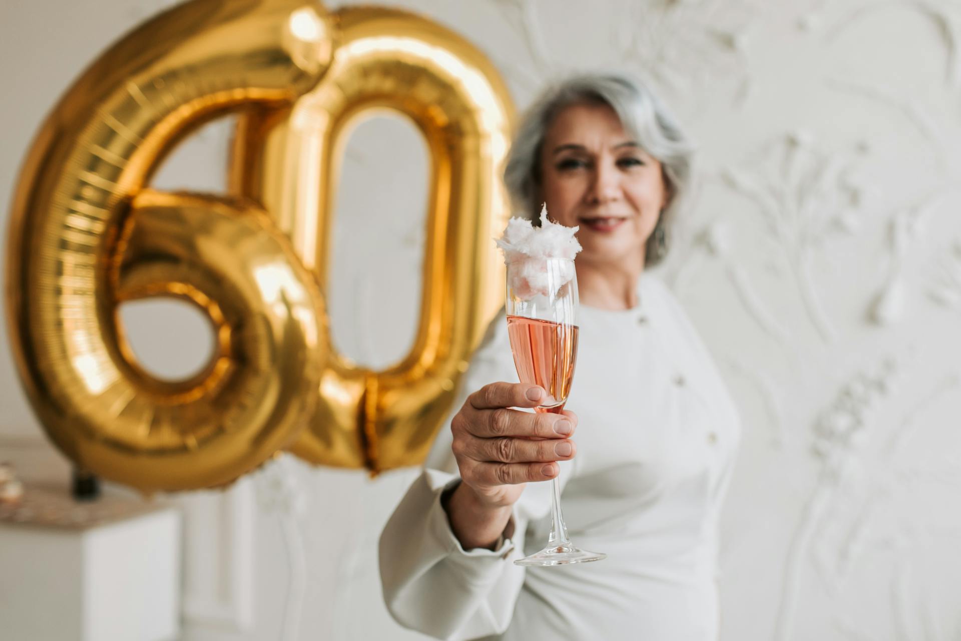 A smiling woman holding a beverage glass | Source: Pexels