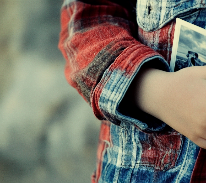 A boy holding a photograph | Source: Midjourney