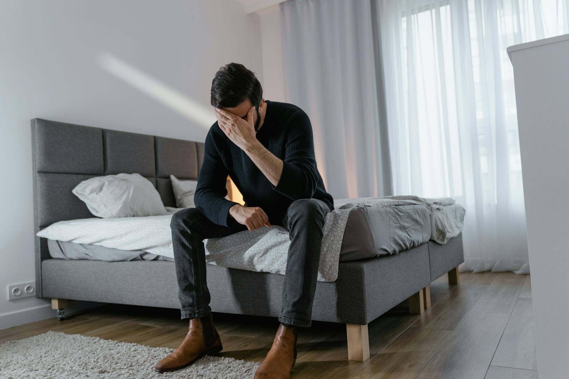 A distressed man sitting on the edge of the bed | Source: Pexels