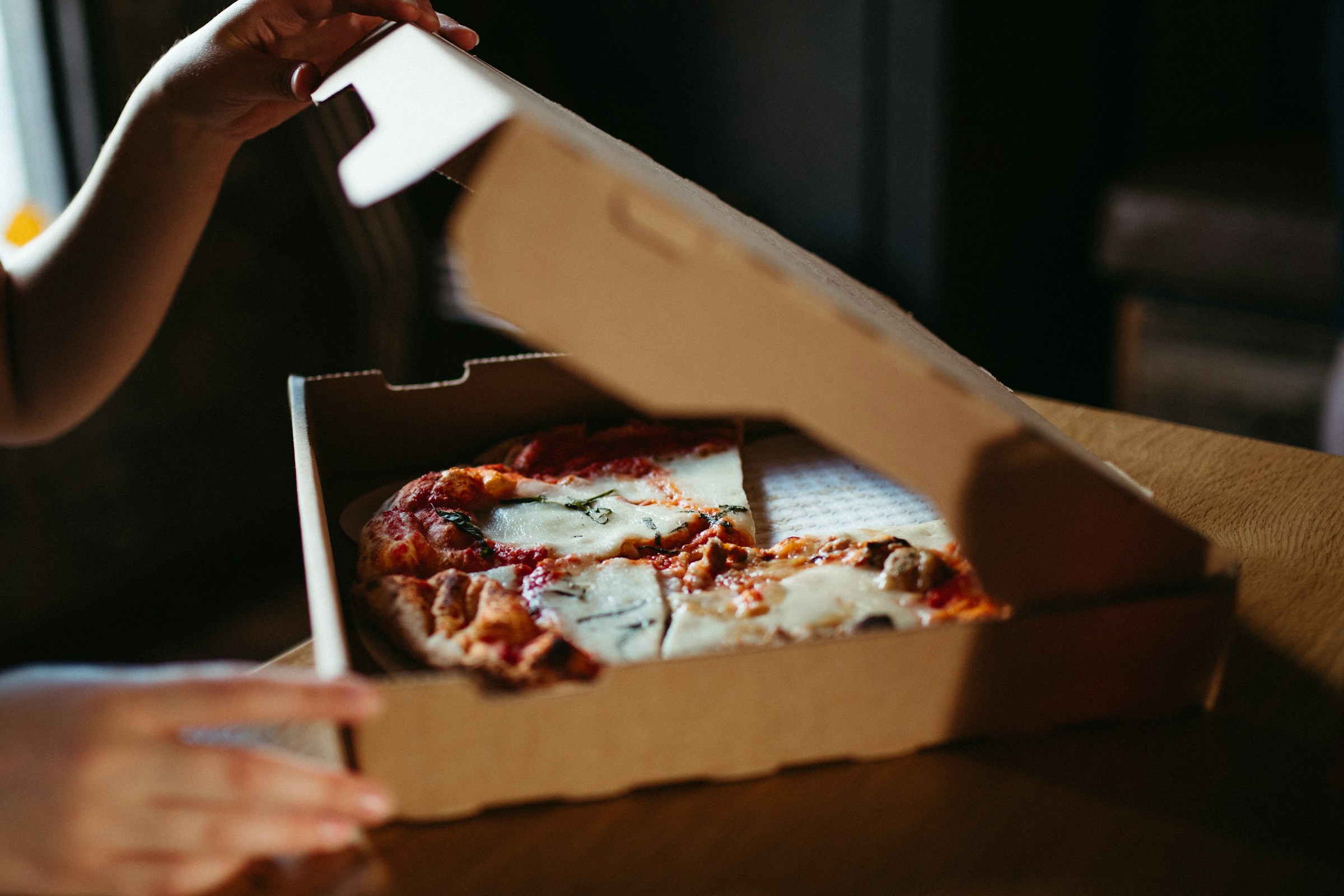 A person opening a pizza box | Source: Pexels