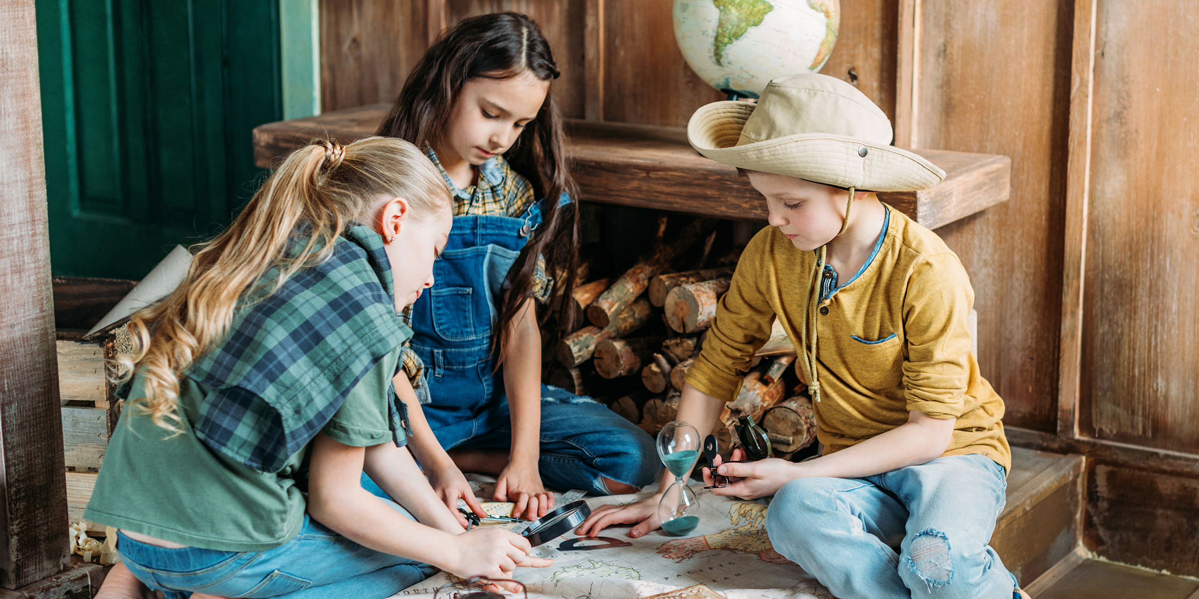 Three children playing with a map | Source: Shutterstock