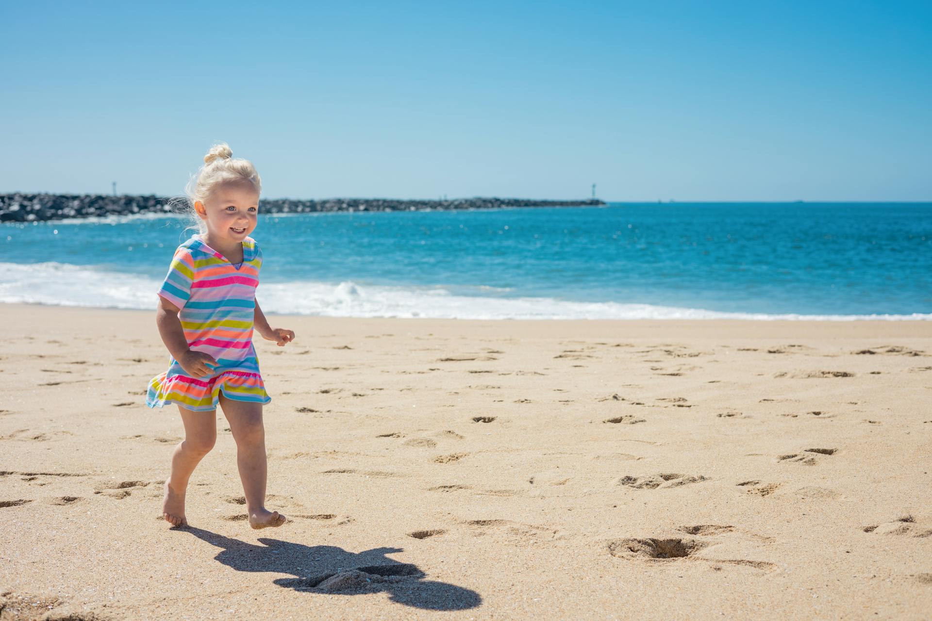 A little girl running on the beach | Source: Pexels