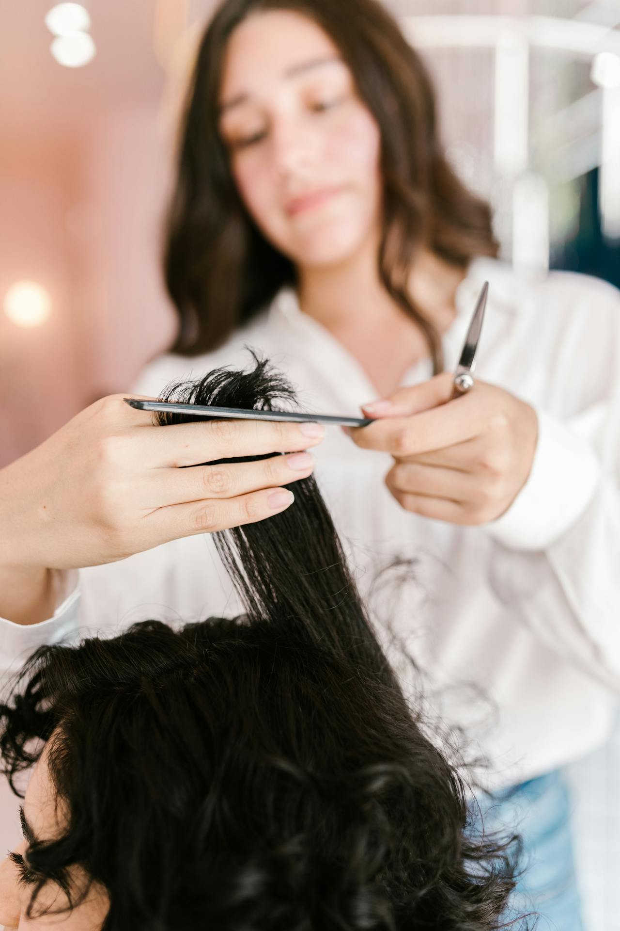 A stylist cutting a woman's hair in a salon | Source: Pexels