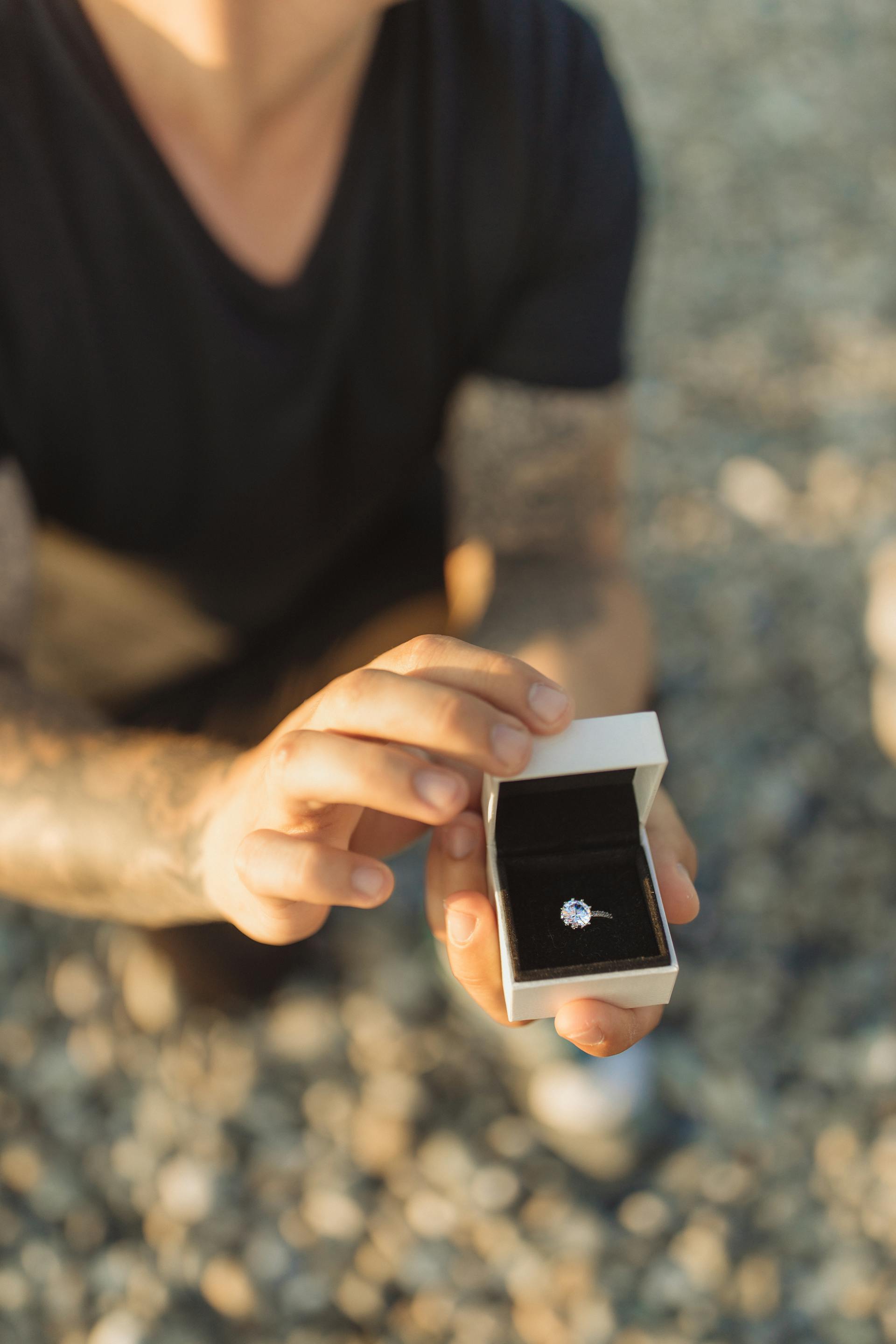 A close-up shot of a man kneeling down, holding a box of ring | Source: Pexels