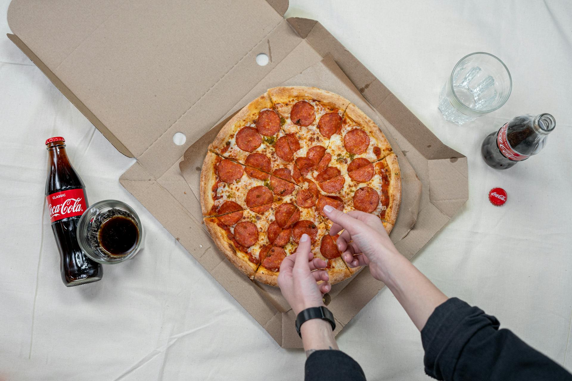 A person taking a slice of pizza | Source: Pexels