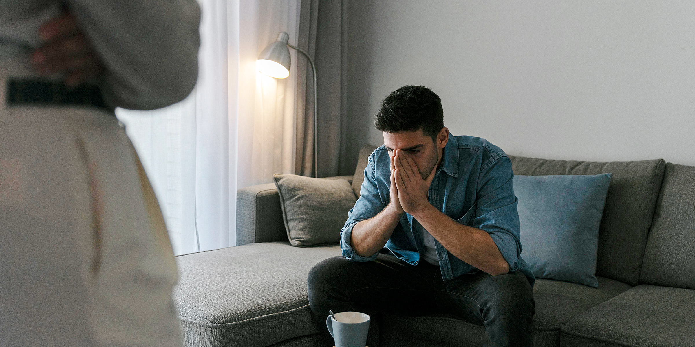 A man sitting on a couch with his hands on his face | Source: Freepik