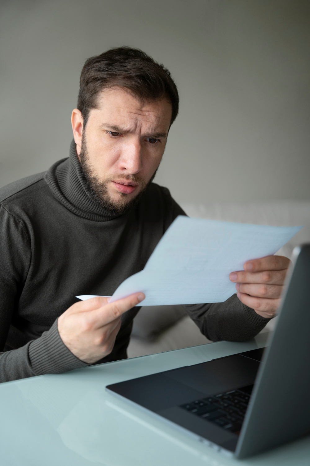 A stunned man looking at a sheet of paper | Source: Freepik