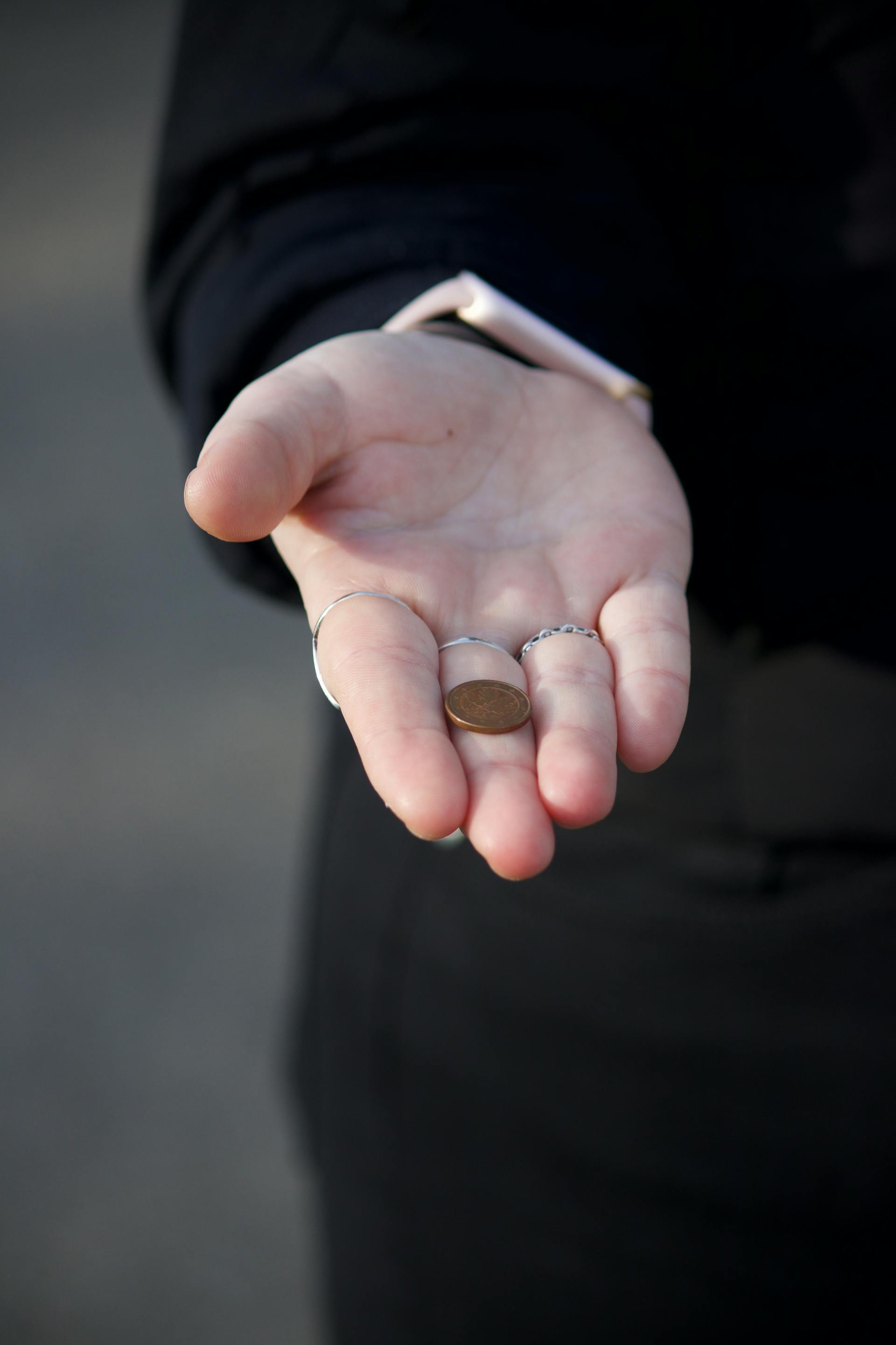 A close-up of a hand holding a coin | Source: Pexels