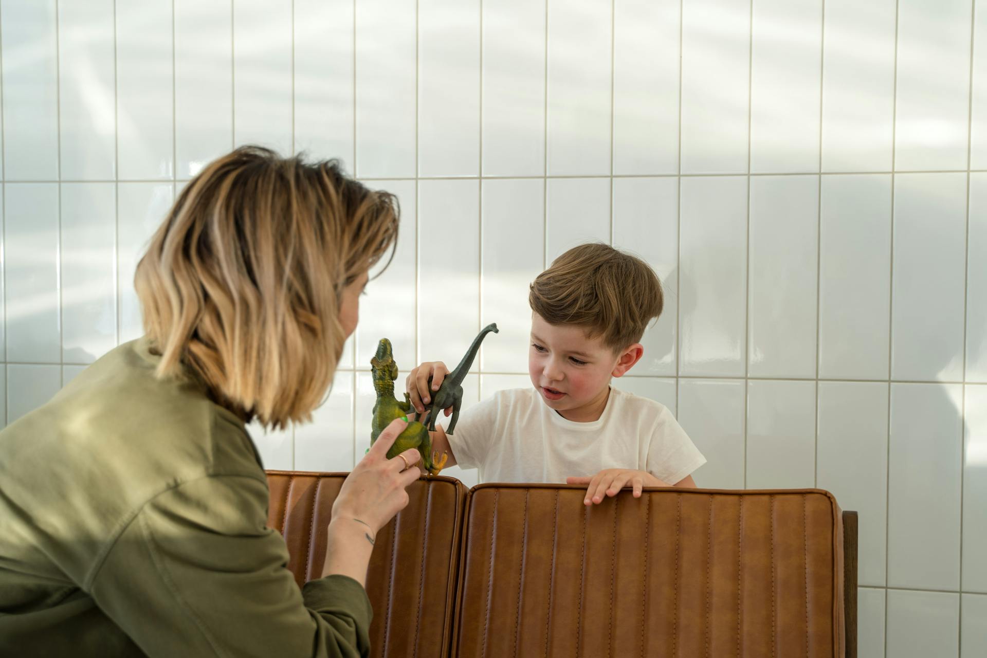 A woman playing with her son on a bench | Source: Pexels