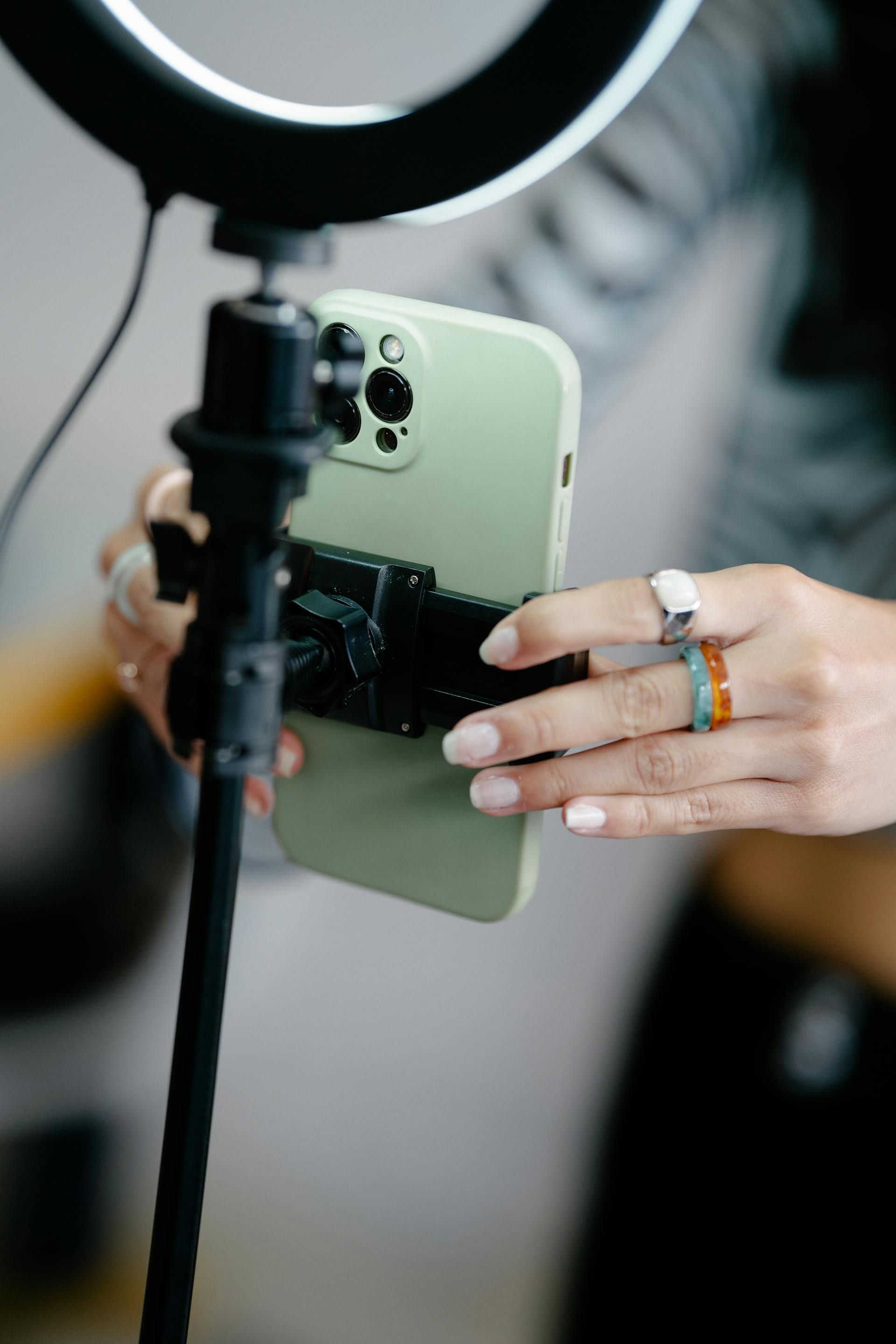 Une femme fixe un téléphone sur un trépied | Source : Pexels