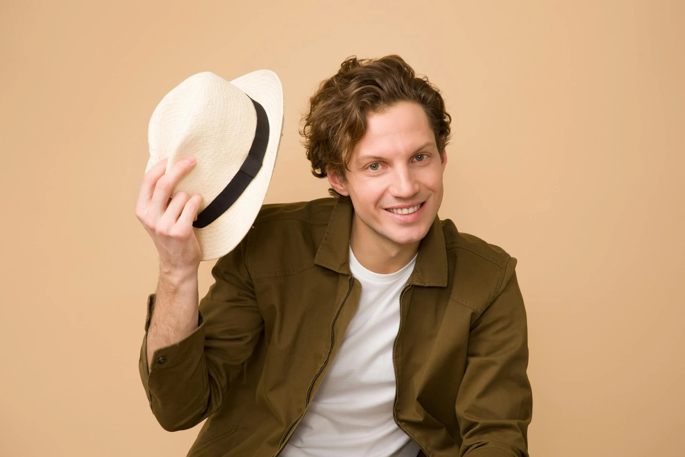 A smiling man holding his hat | Source: Pexels