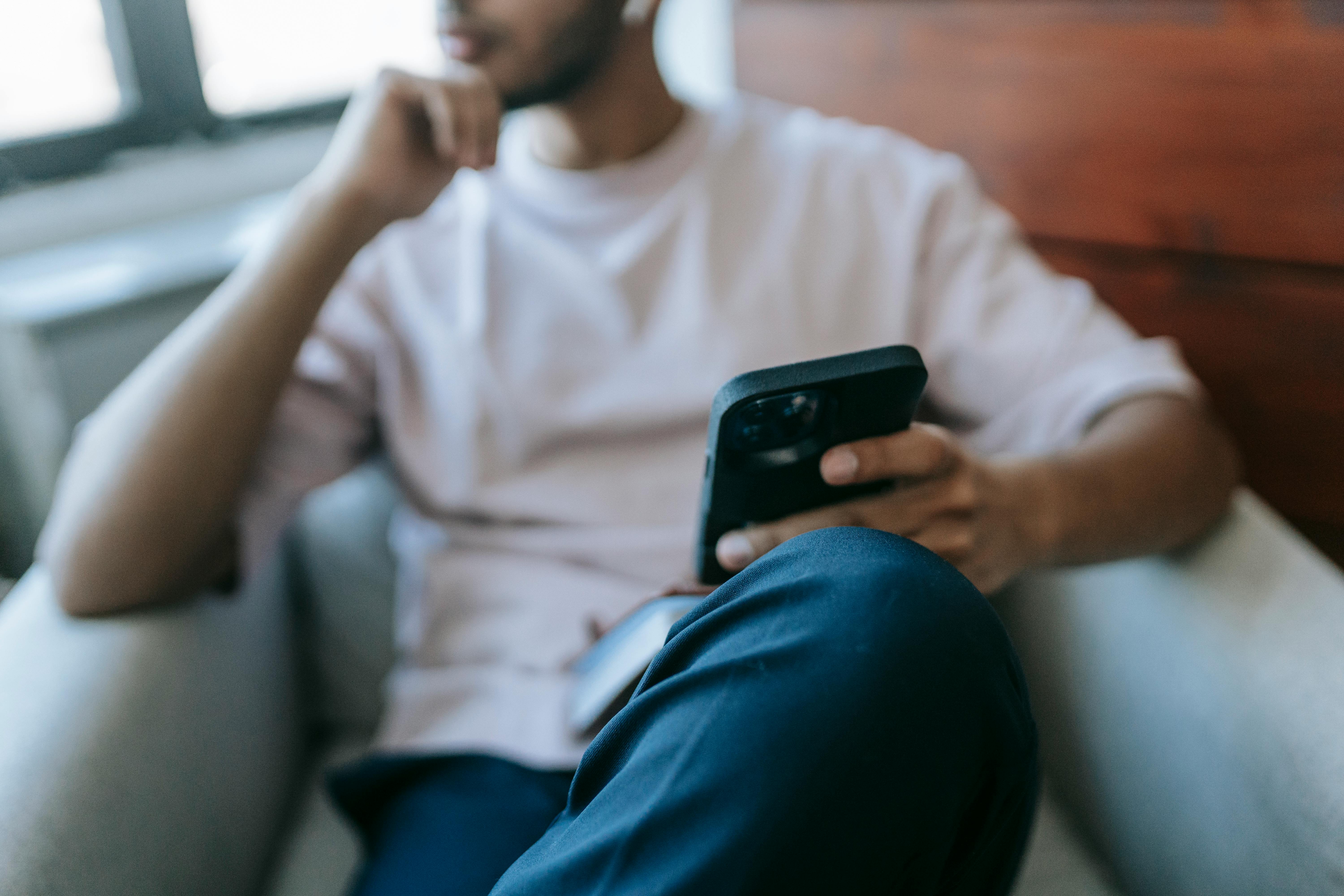 A man deep in thought while holding his phone | Source: Pexels