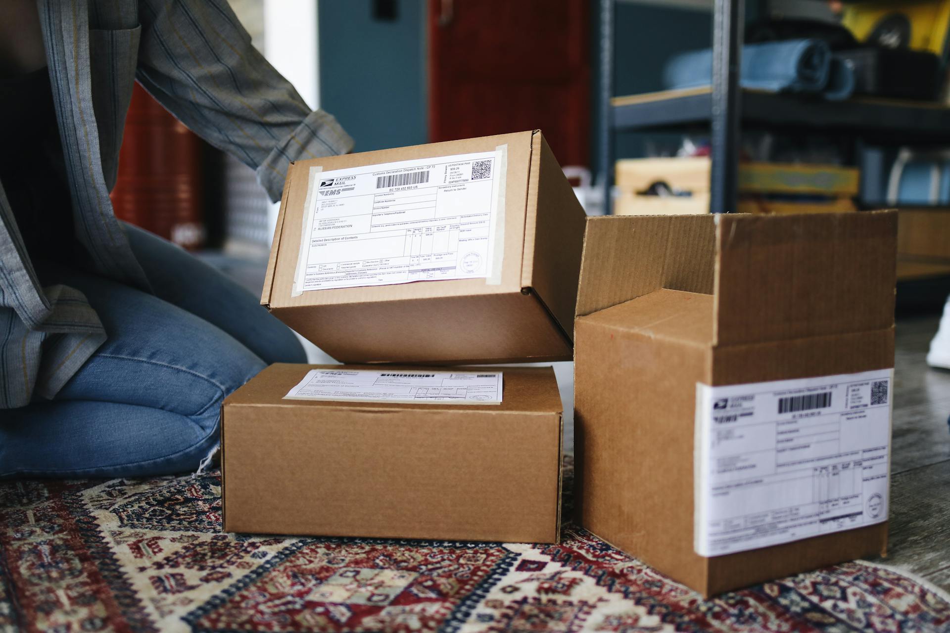 A woman kneeling beside her delivered parcels | Source: Pexels